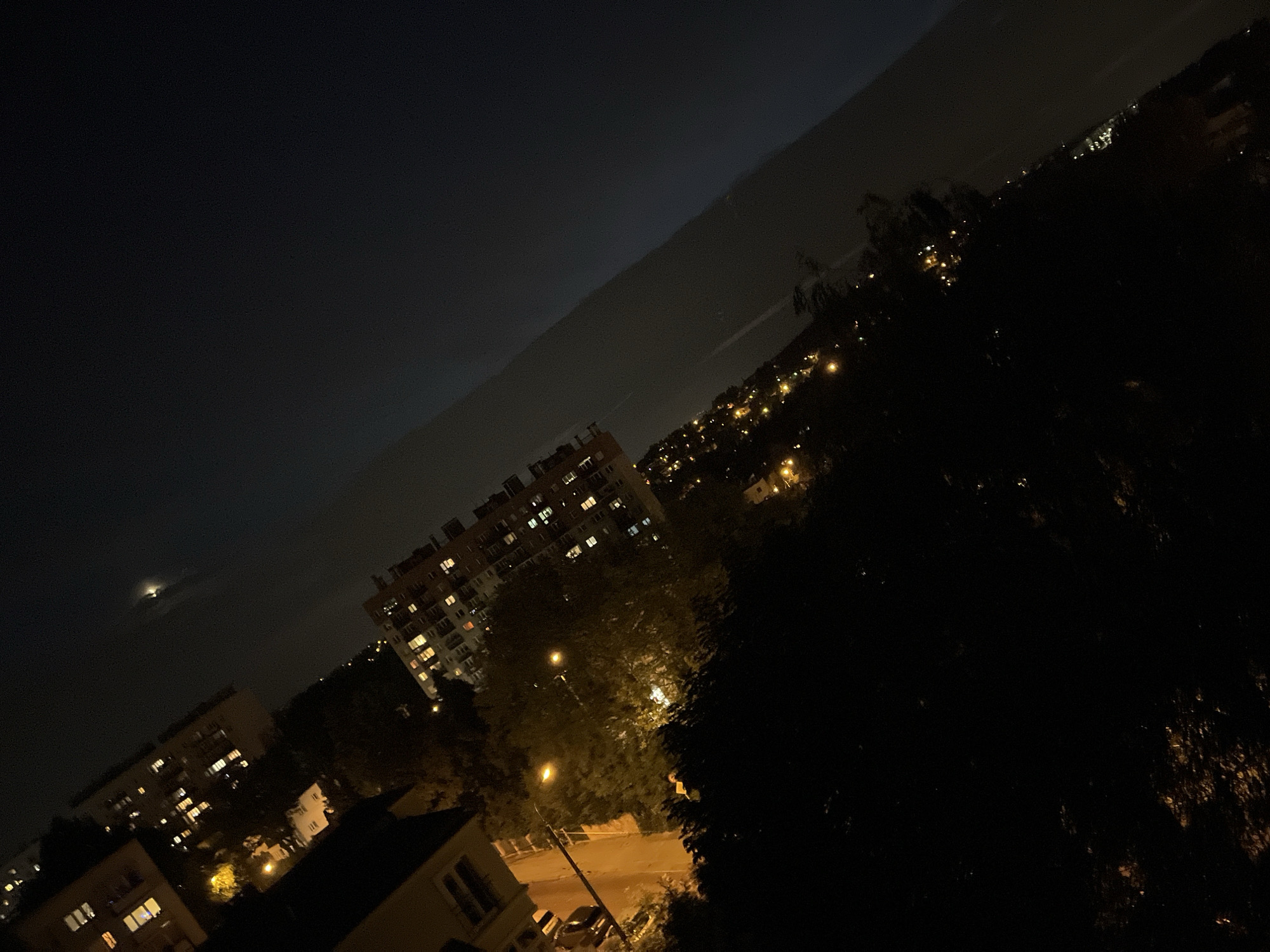Evening in the city: crescent moon, apartment lights, rooftop vibes
