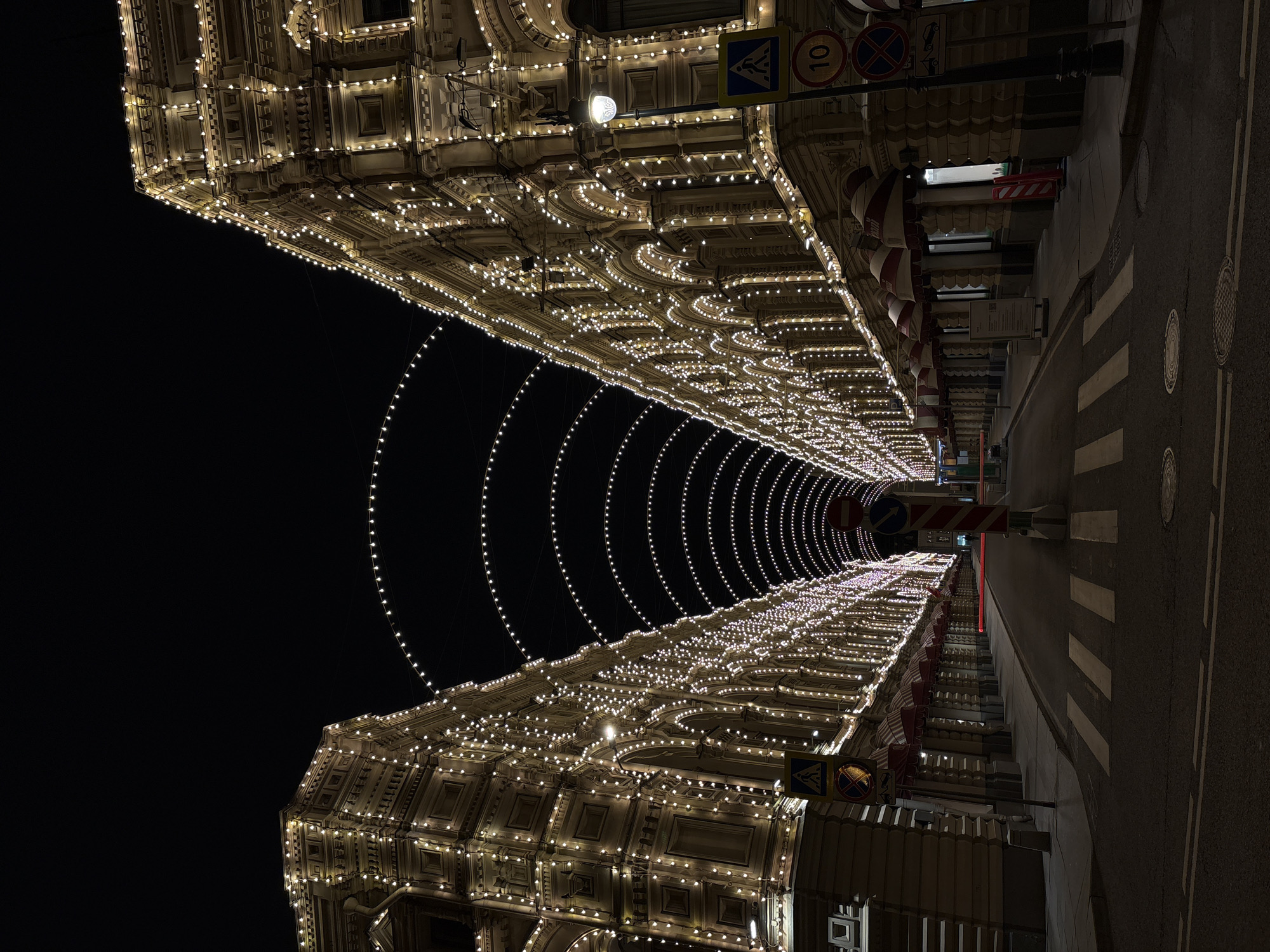 Nighttime street illuminated with extensive warm architectural lighting display
