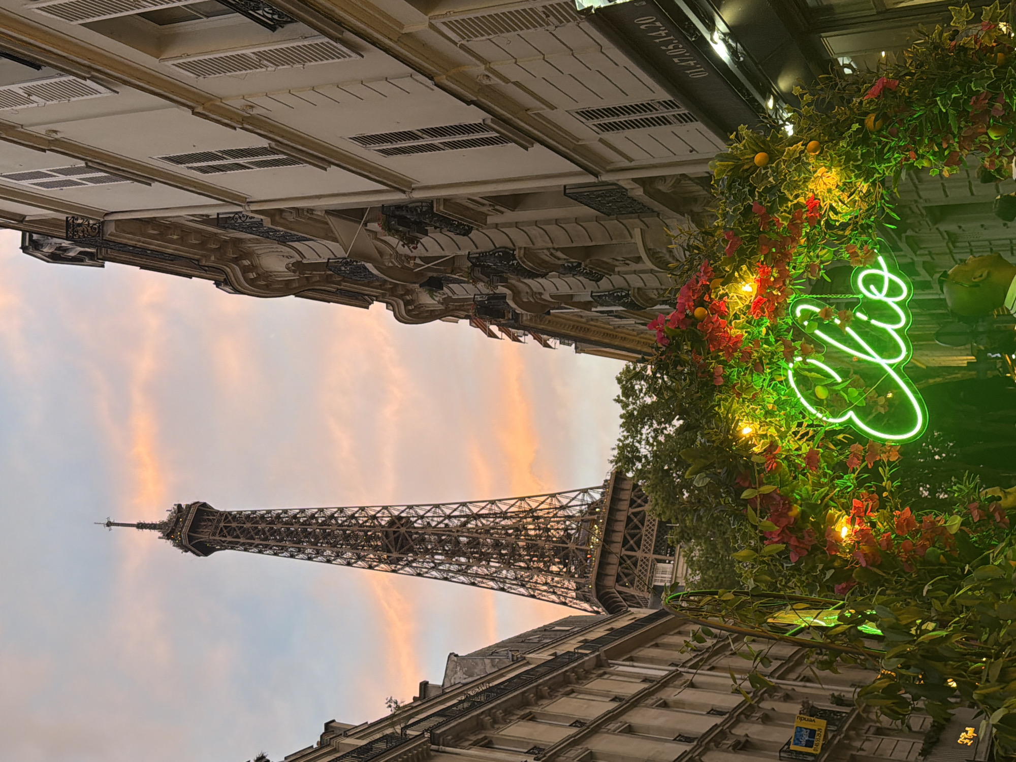 Eiffel Tower glows under a pink and orange sunset sky