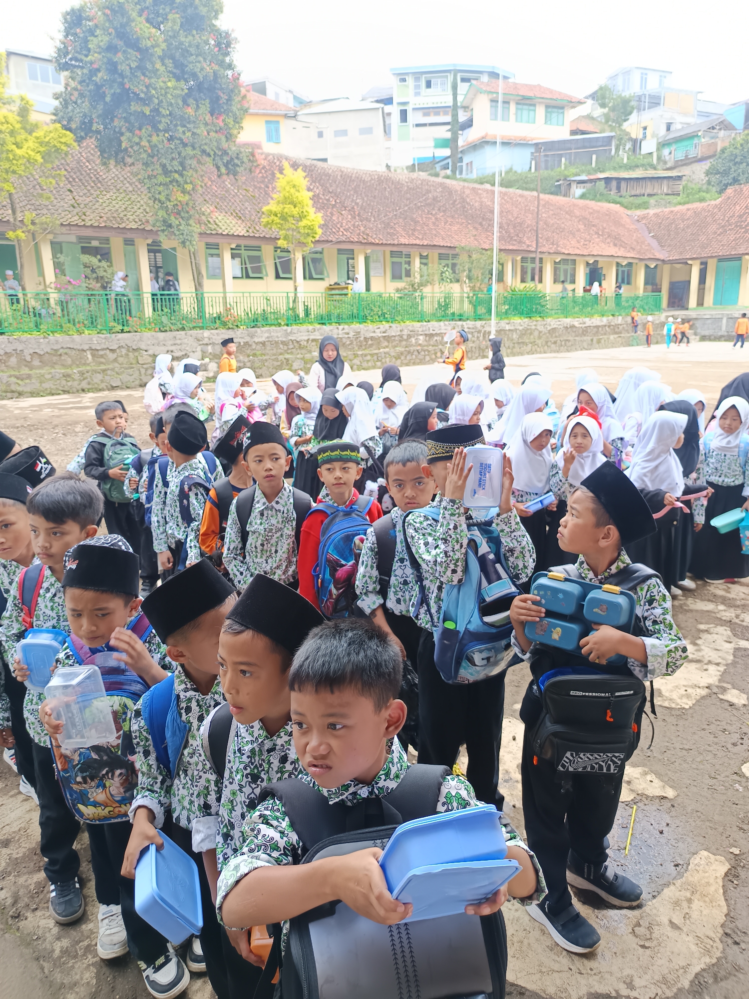 Indonesian schoolchildren gather in uniforms at outdoor school areas