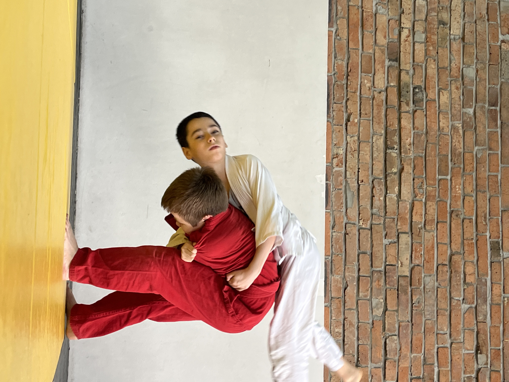 Young judoka practice grappling techniques in Krasnoyarsk training facility