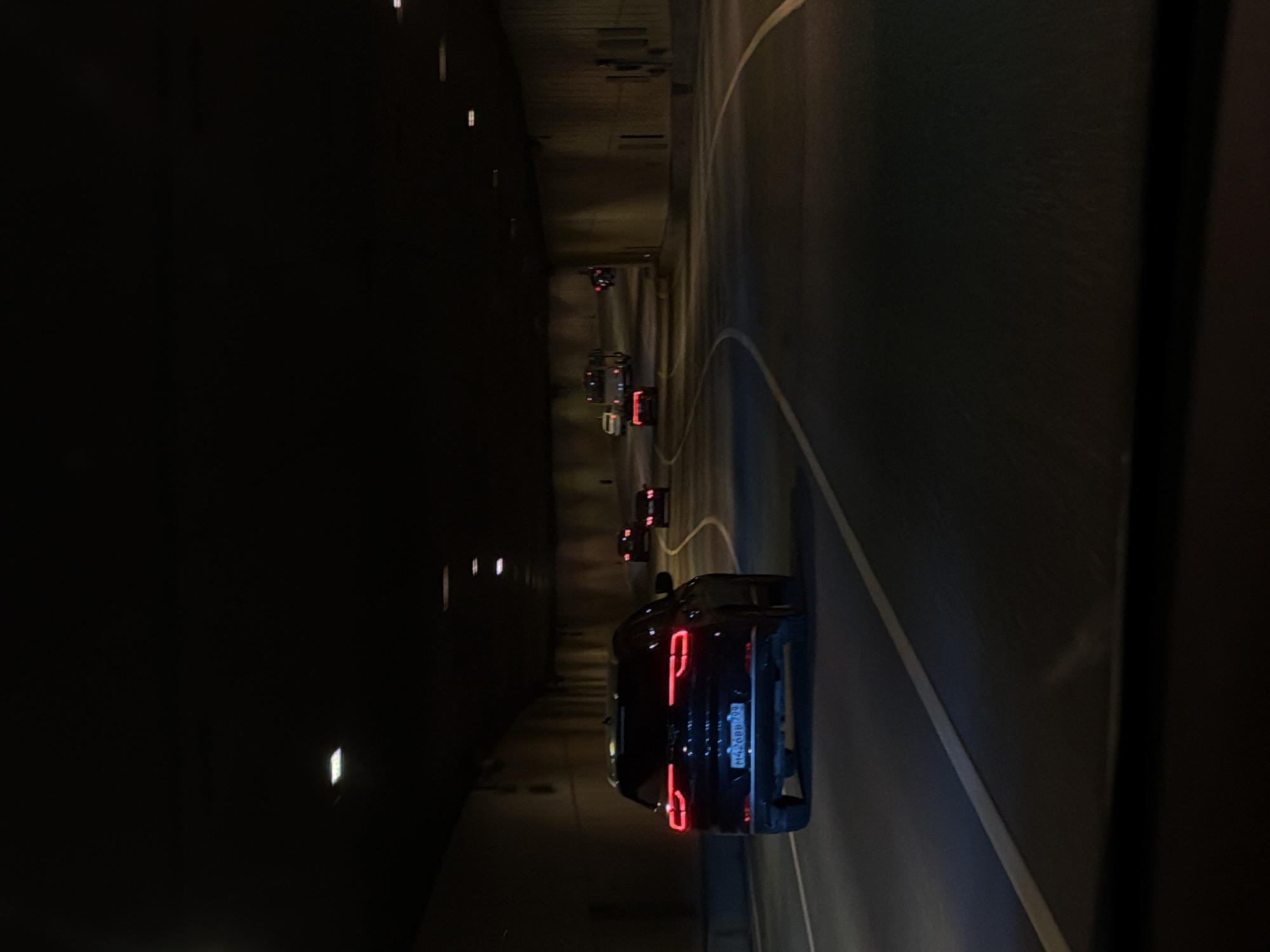 Vehicle travels through illuminated tunnel in Moscow evening