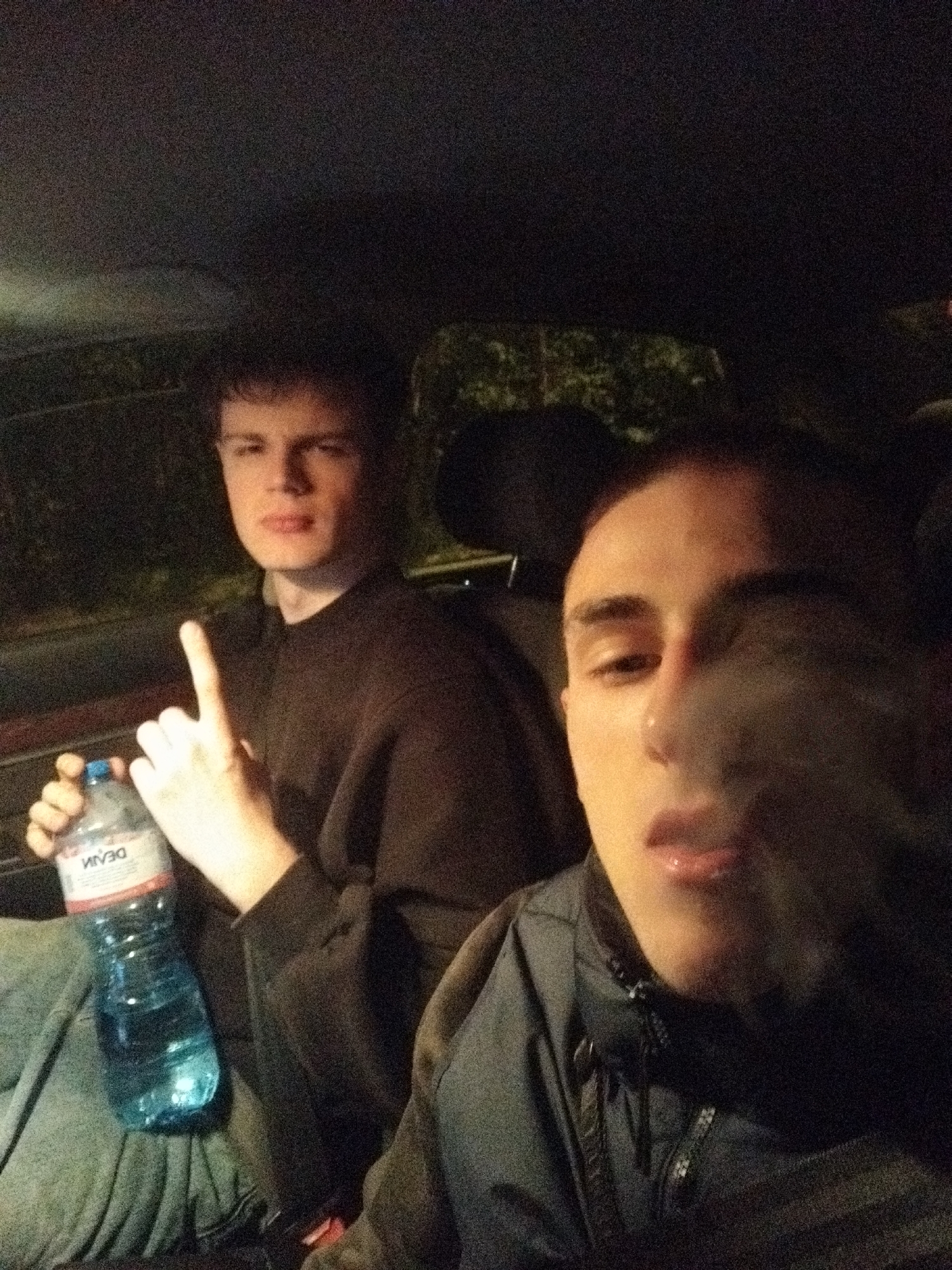 Two males smoking in car during evening in Sofia