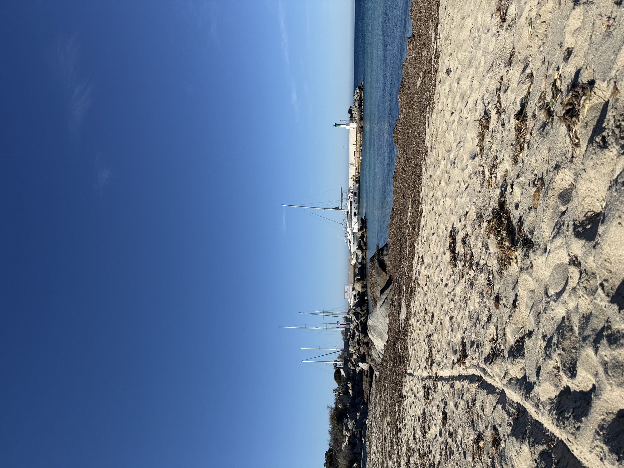 Clear skies and footprints mark quiet afternoon at Lumio beach
