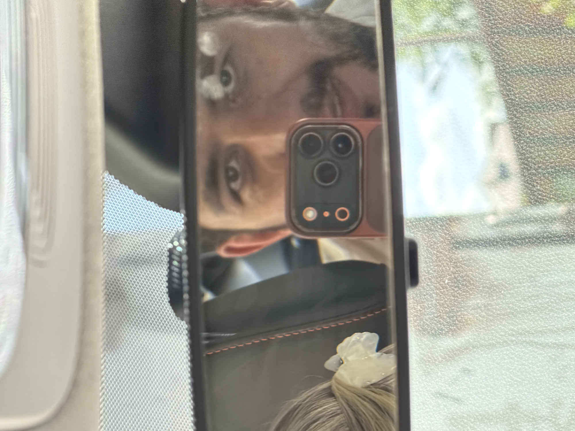 Woman driving photographed via rearview mirror in Krasnoyarsk