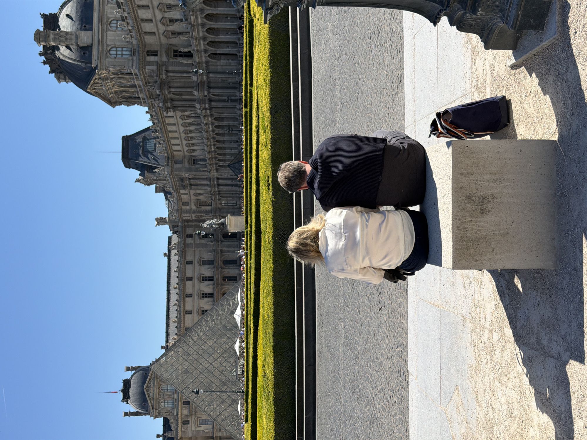 Heavy tourist crowds queue at Louvre Museum on sunny Paris afternoon