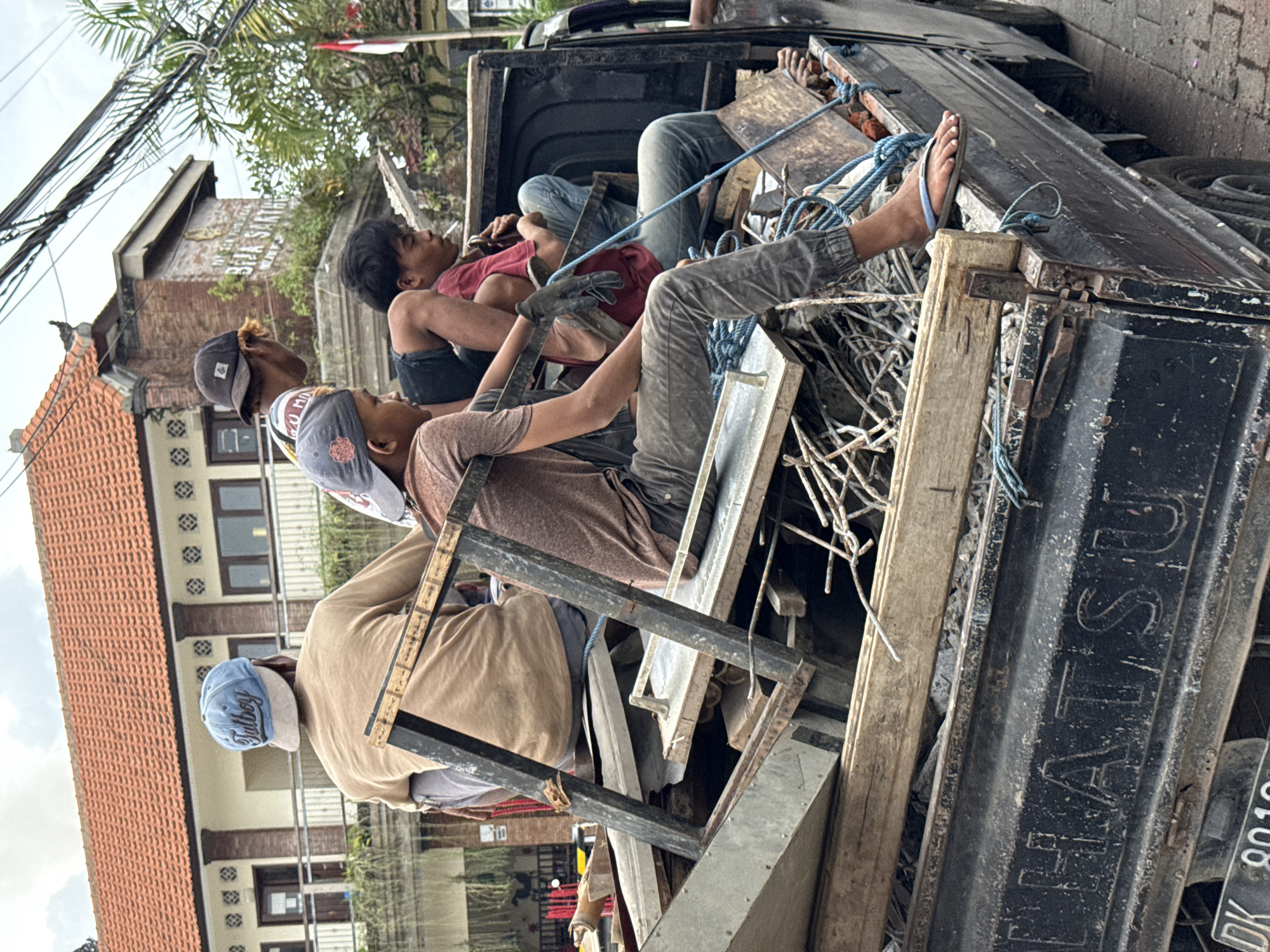 Men transport scrap materials by pickup truck in Ubud