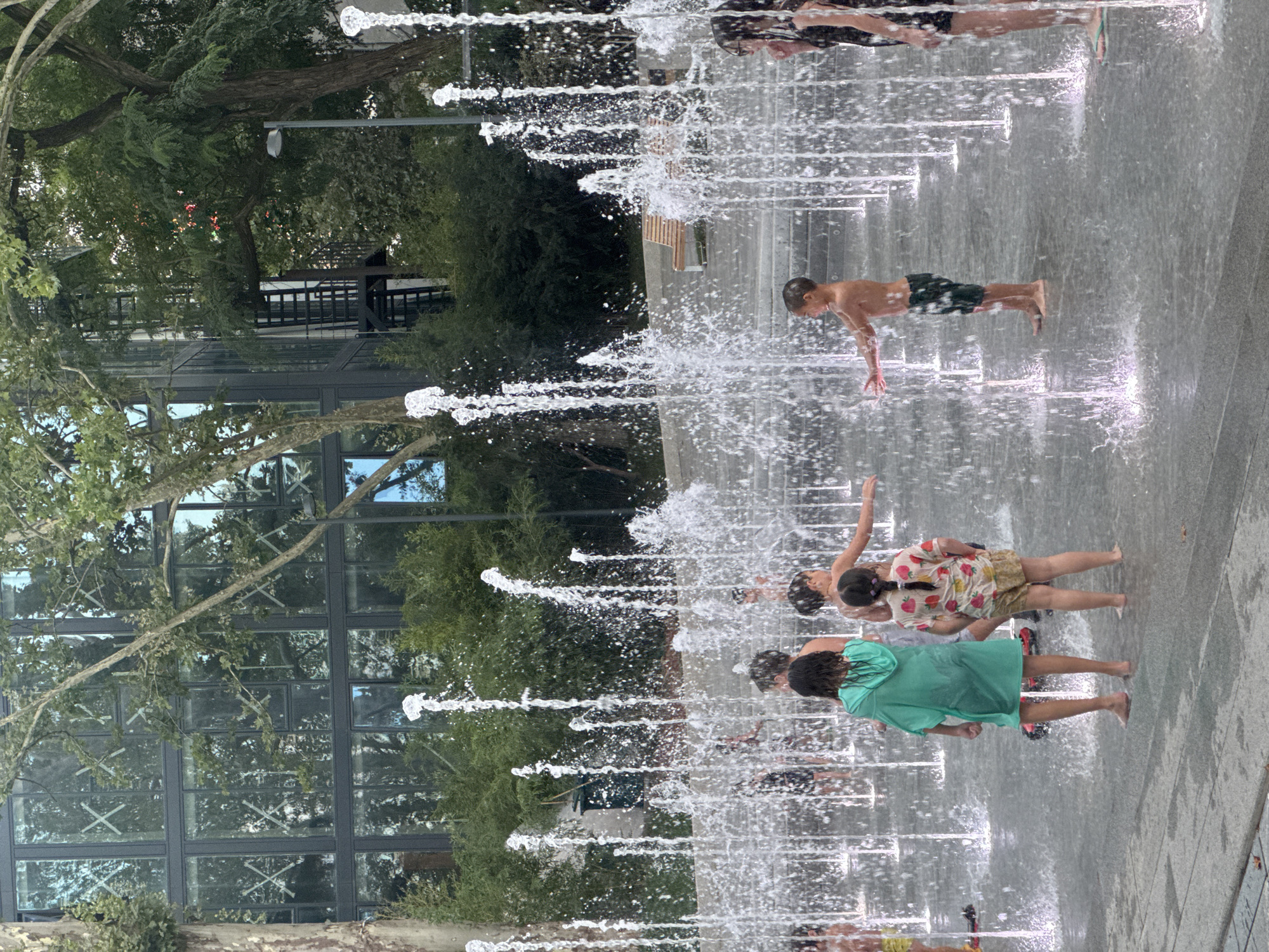 Kids cool off at a Tbilisi splash pad on a summer day