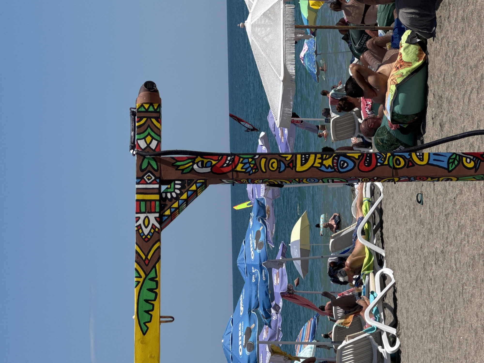 Packed beach day in Burgas, tiki pole front and center