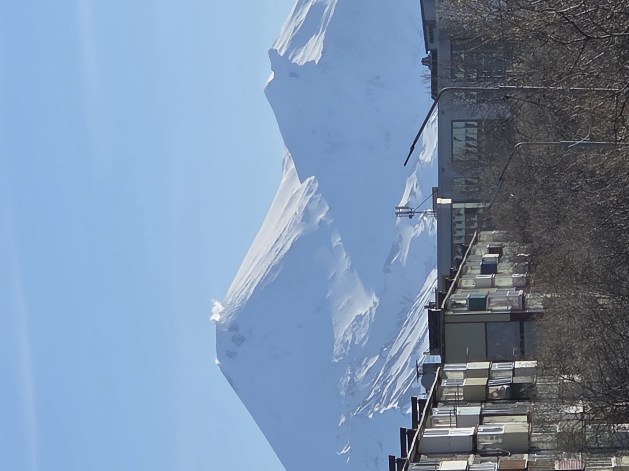 Urban scenes documented in mountainous city with snowy backdrop