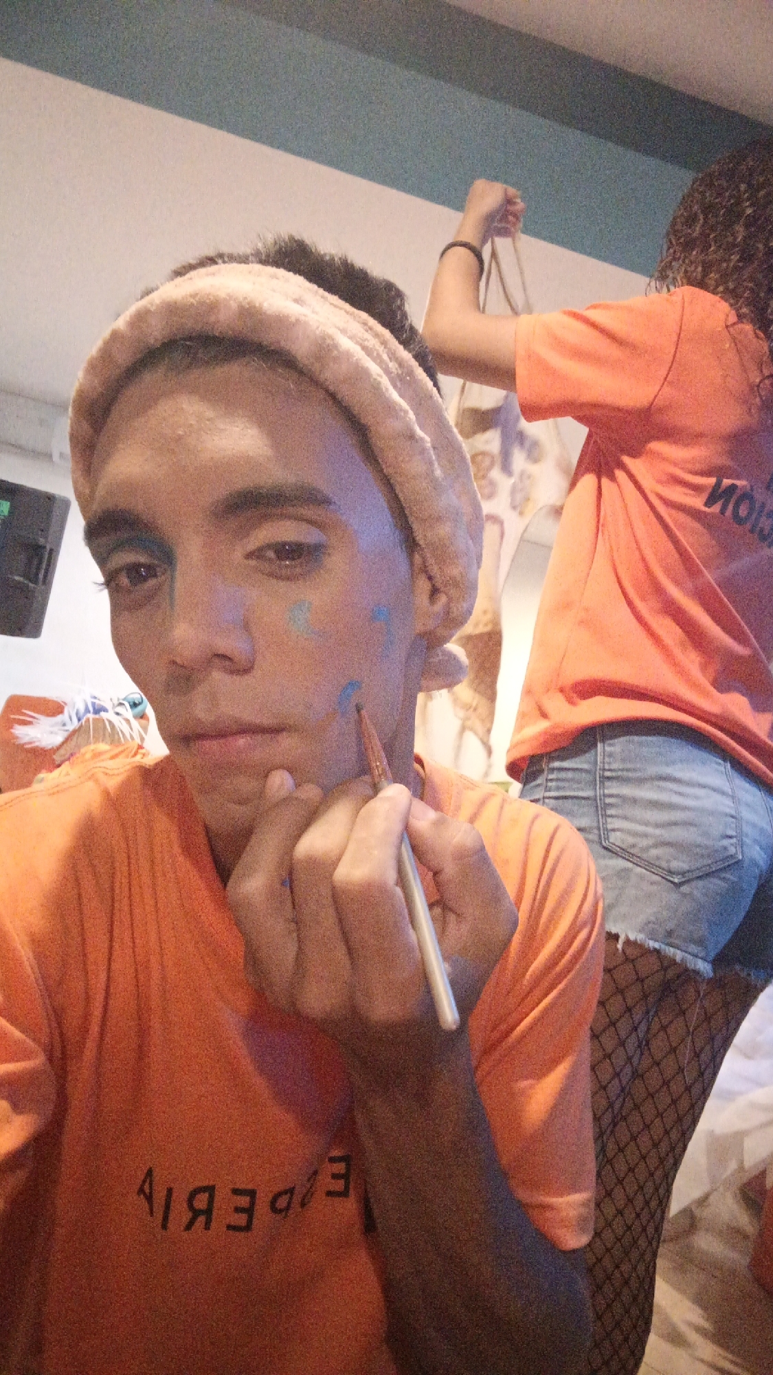 Person applies colorful face paint in Venezuelan beach town