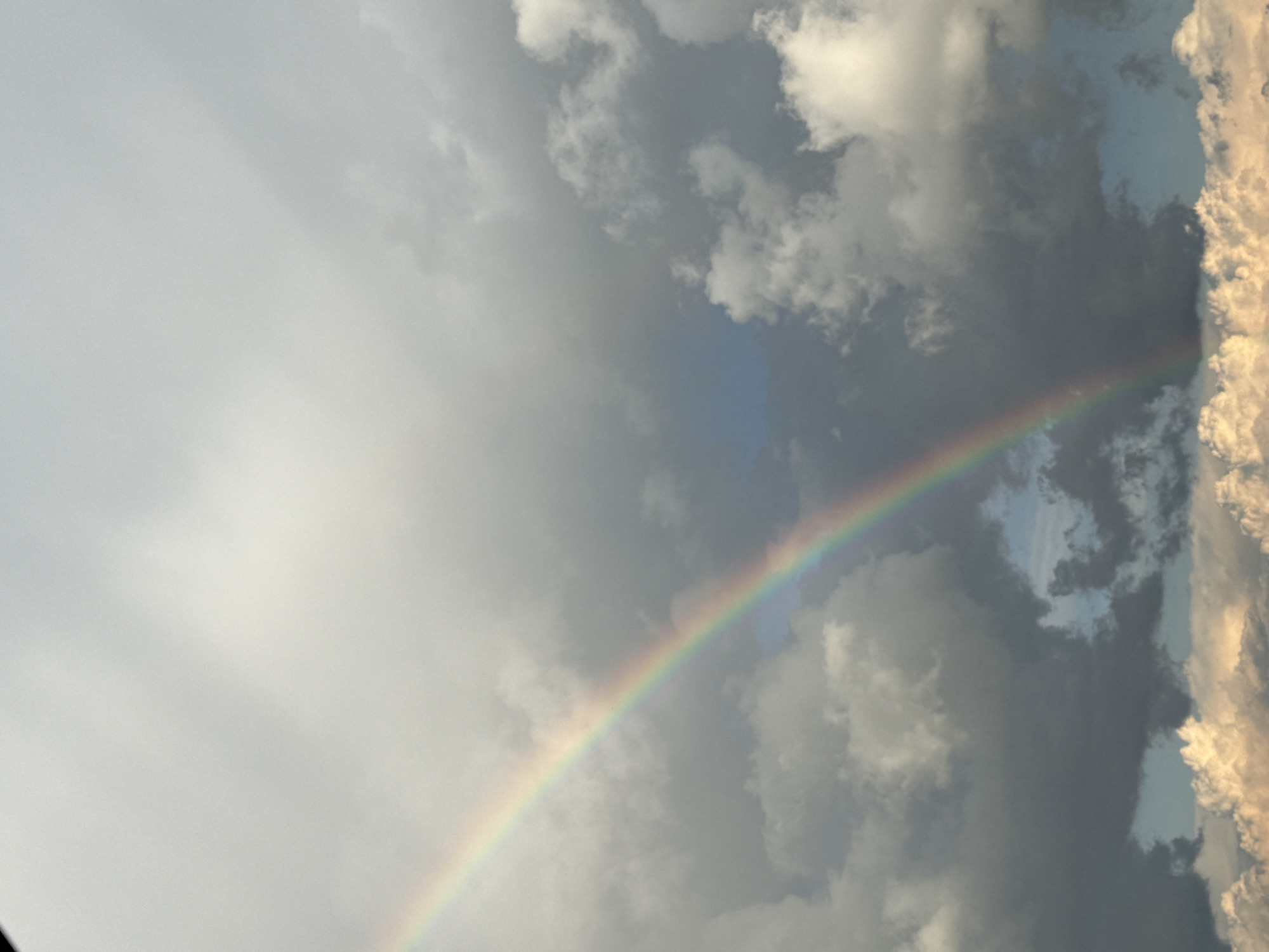Rainbow cuts through brooding storm clouds over rural Russia.