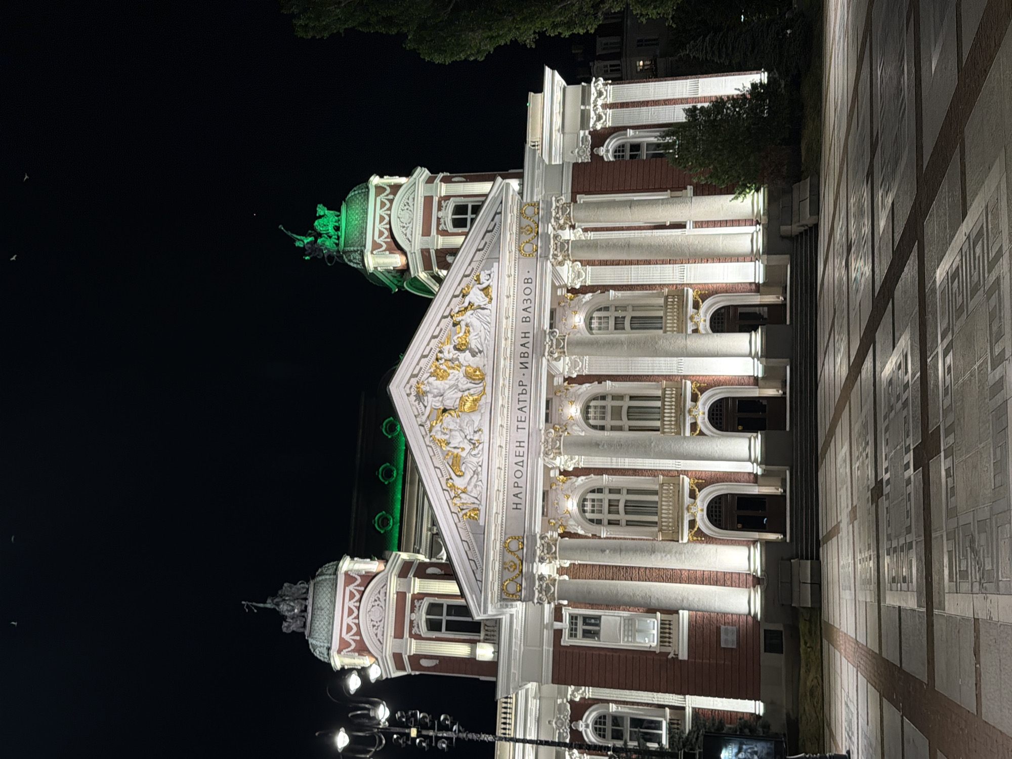 Sofia landmarks glow at night alongside an outdoor evening gathering