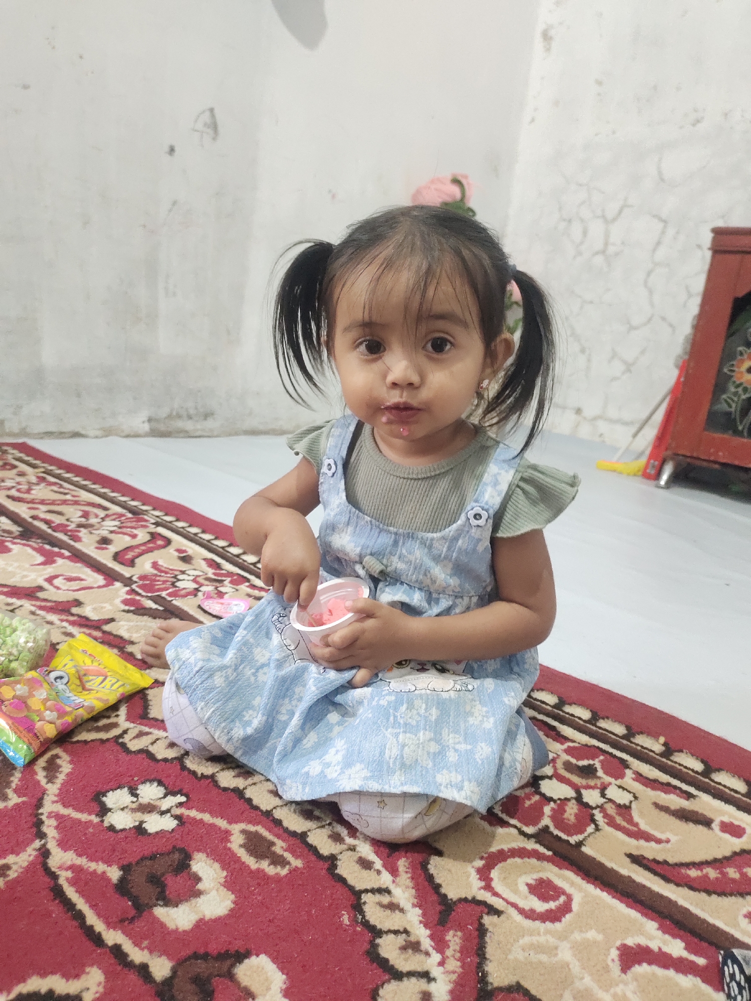 Quiet indoor moment with a cup and spoon on a patterned rug