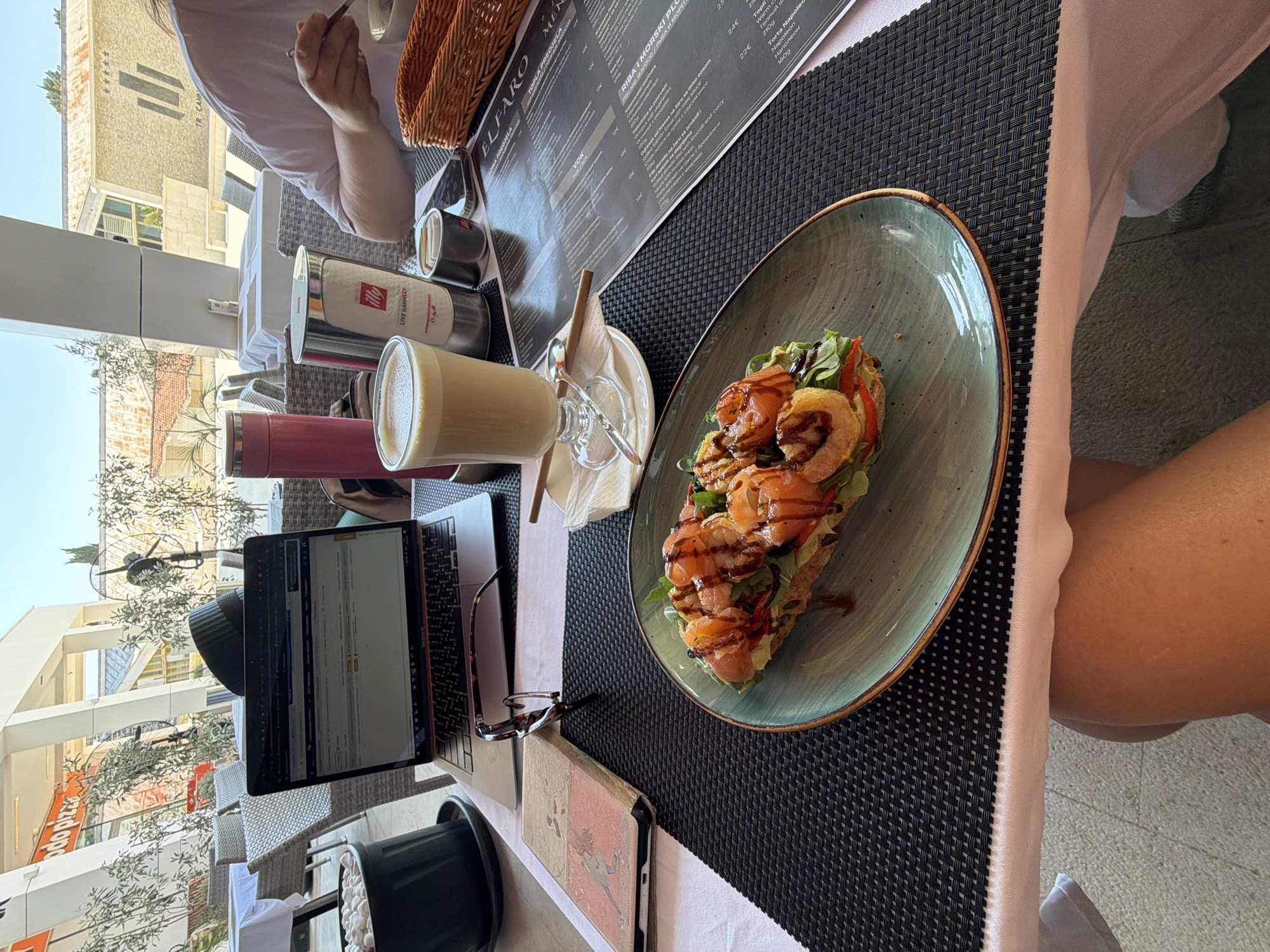 Working morning at a Budva café, streets and buildings nearby