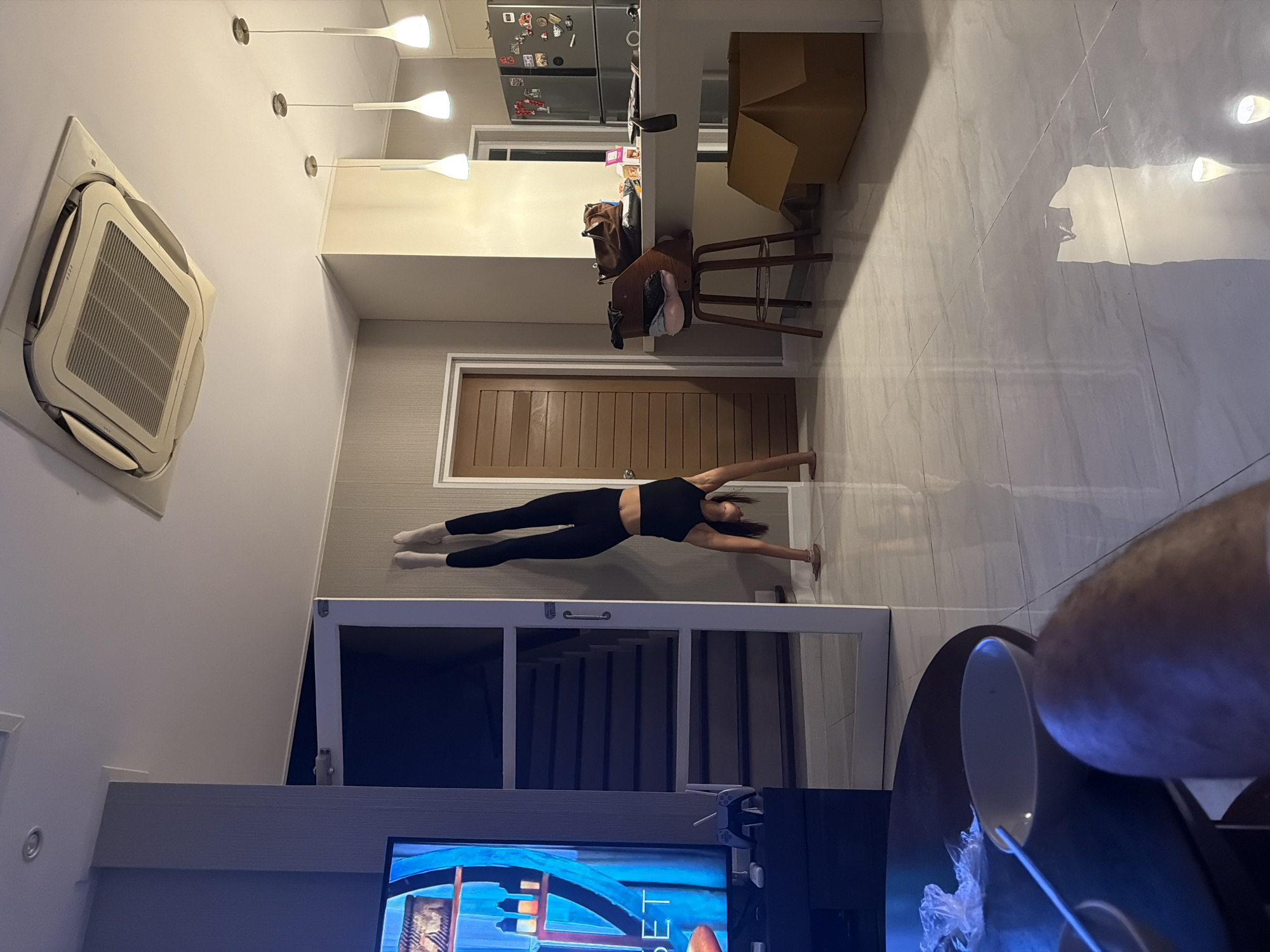 Woman performs split exercise in Chalong home
