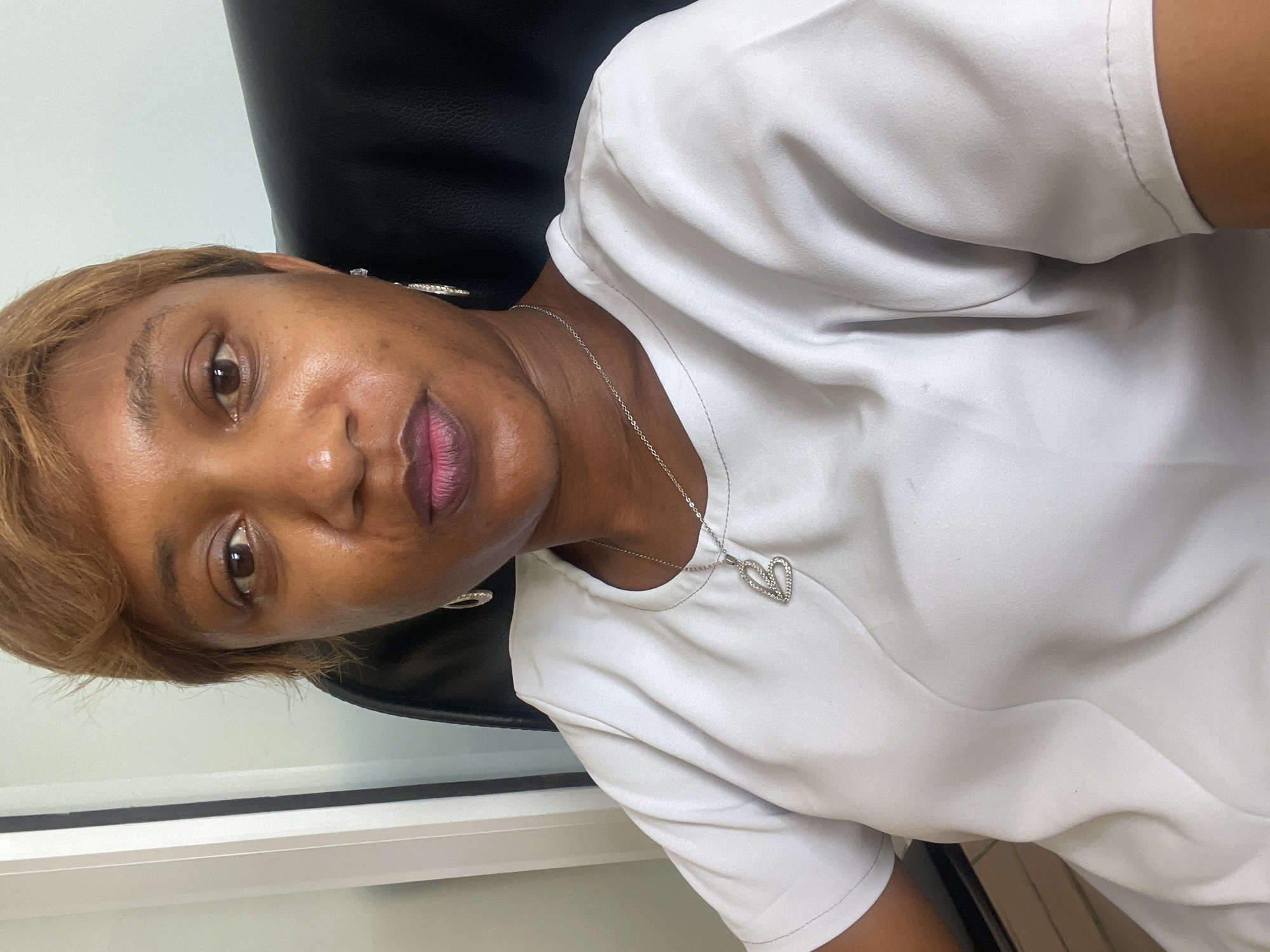Woman in white shirt observed seated in Jos, Nigeria