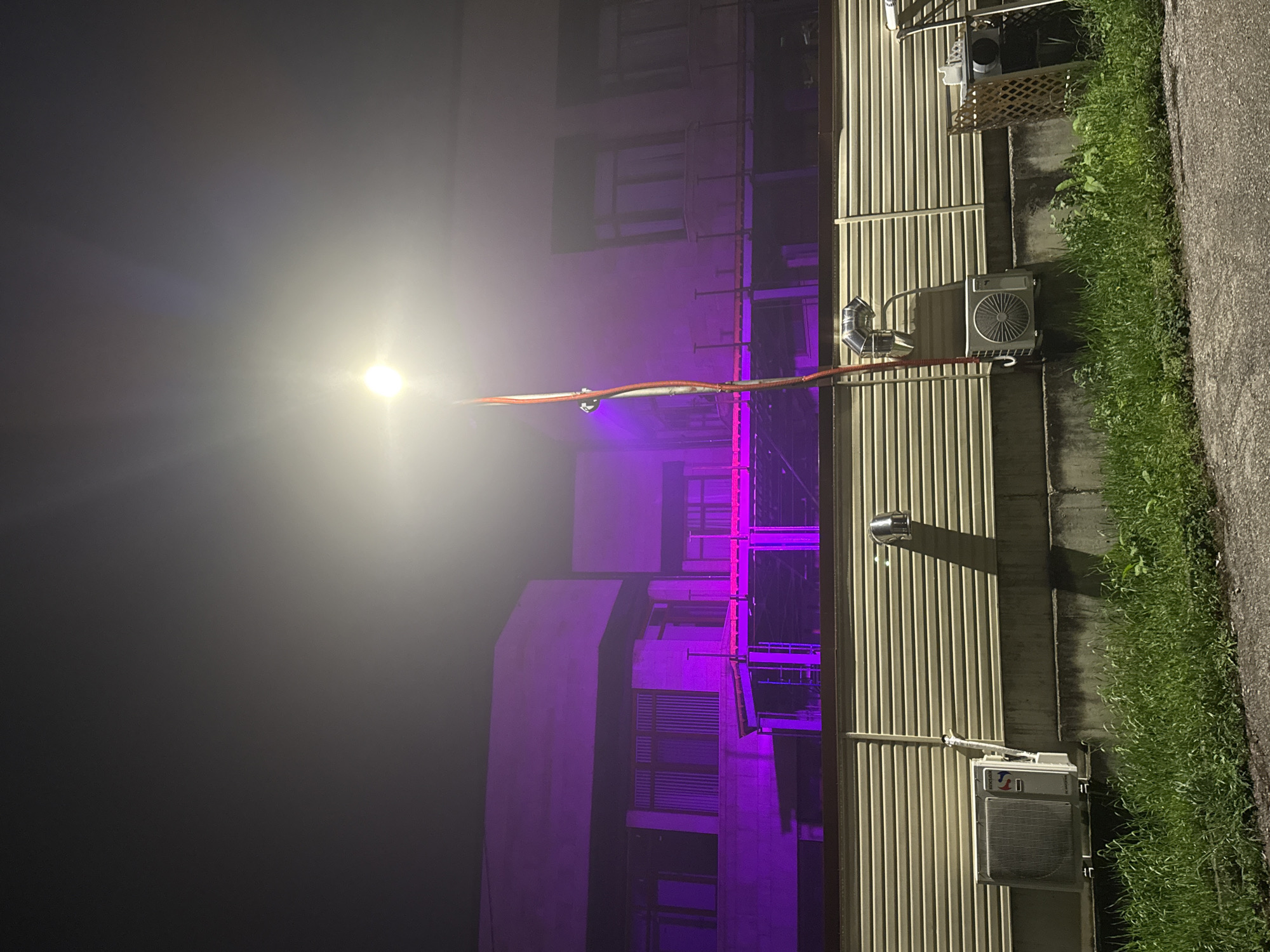 Evening gathering with purple-lit building and dining in Trudovets