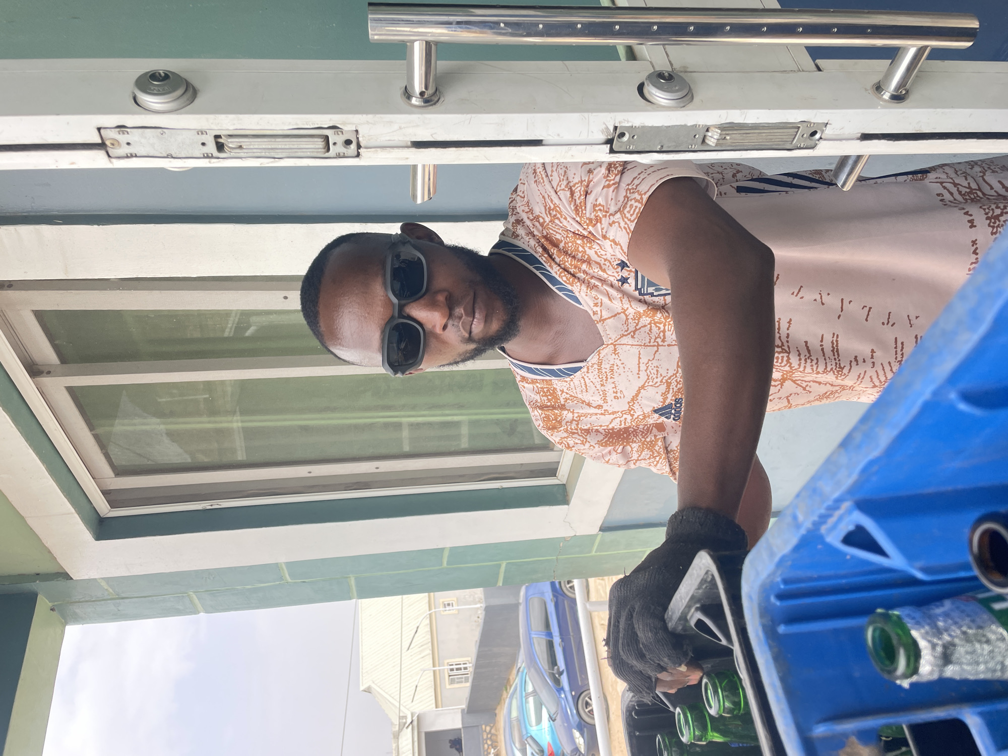 Man carries crate of bottles in Gura Top