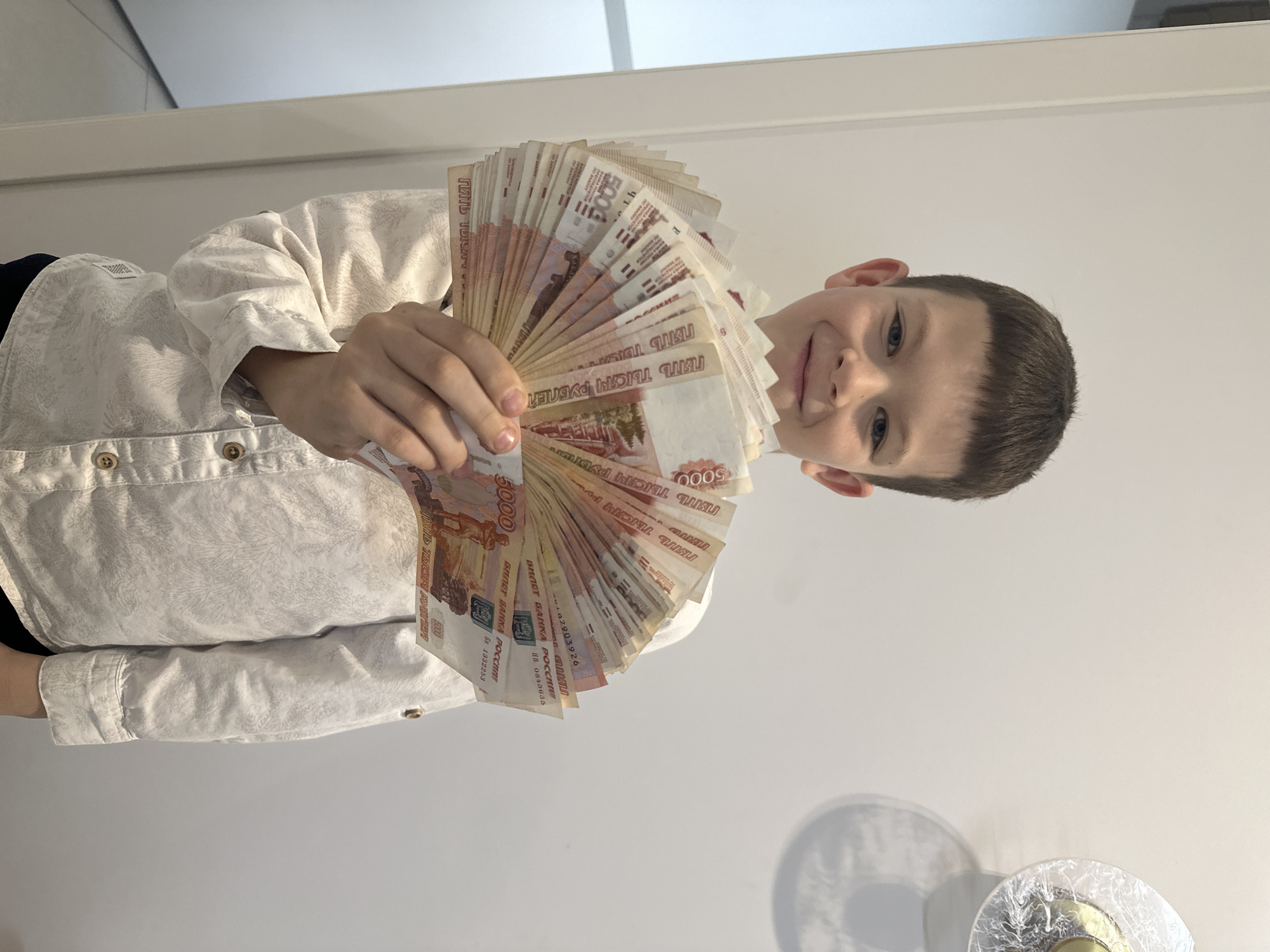 Boy displays cash, dog rides passenger seat in Прикамский