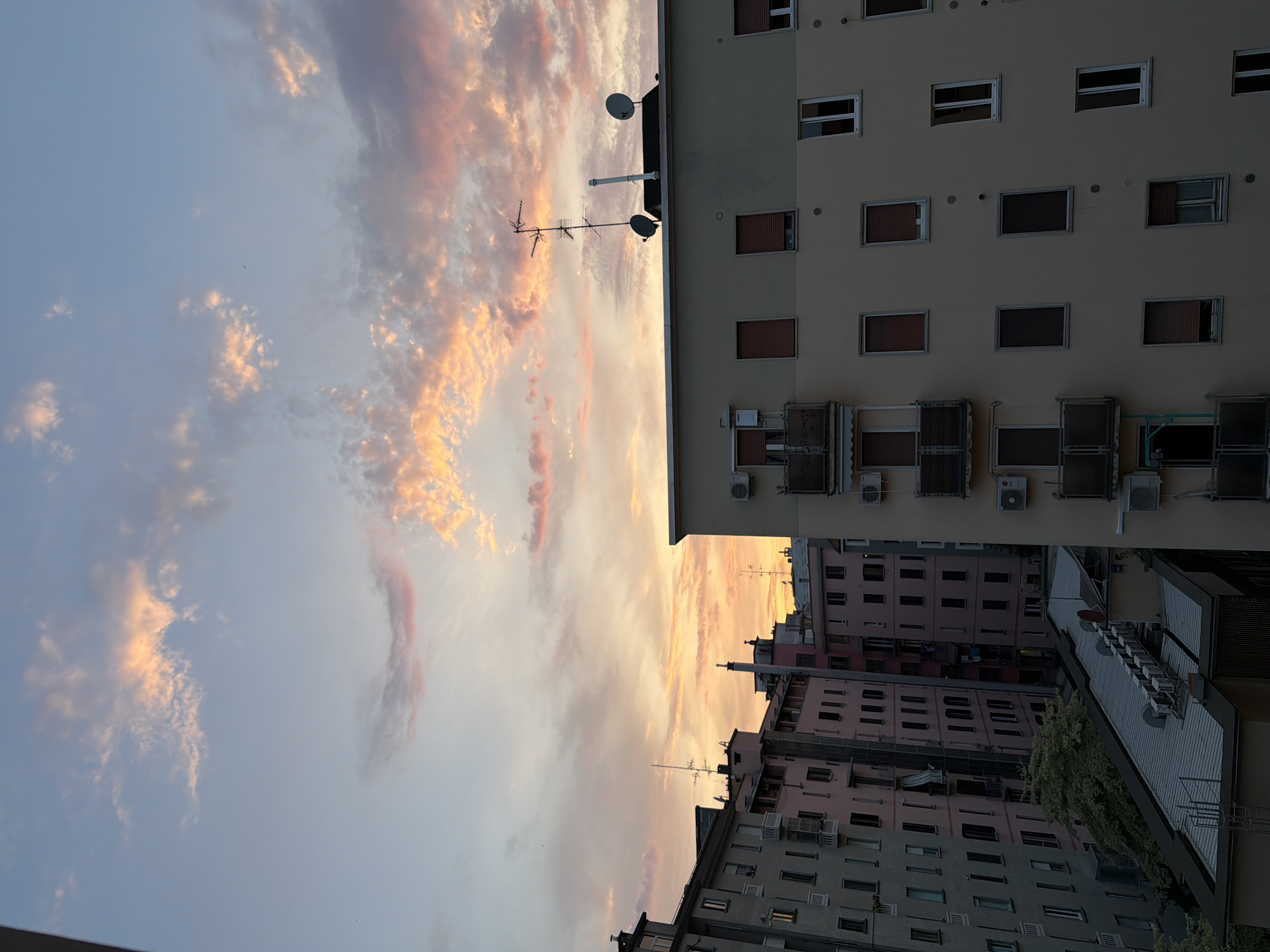 Milan rooftops and sky during a summer sunset-to-dusk transition