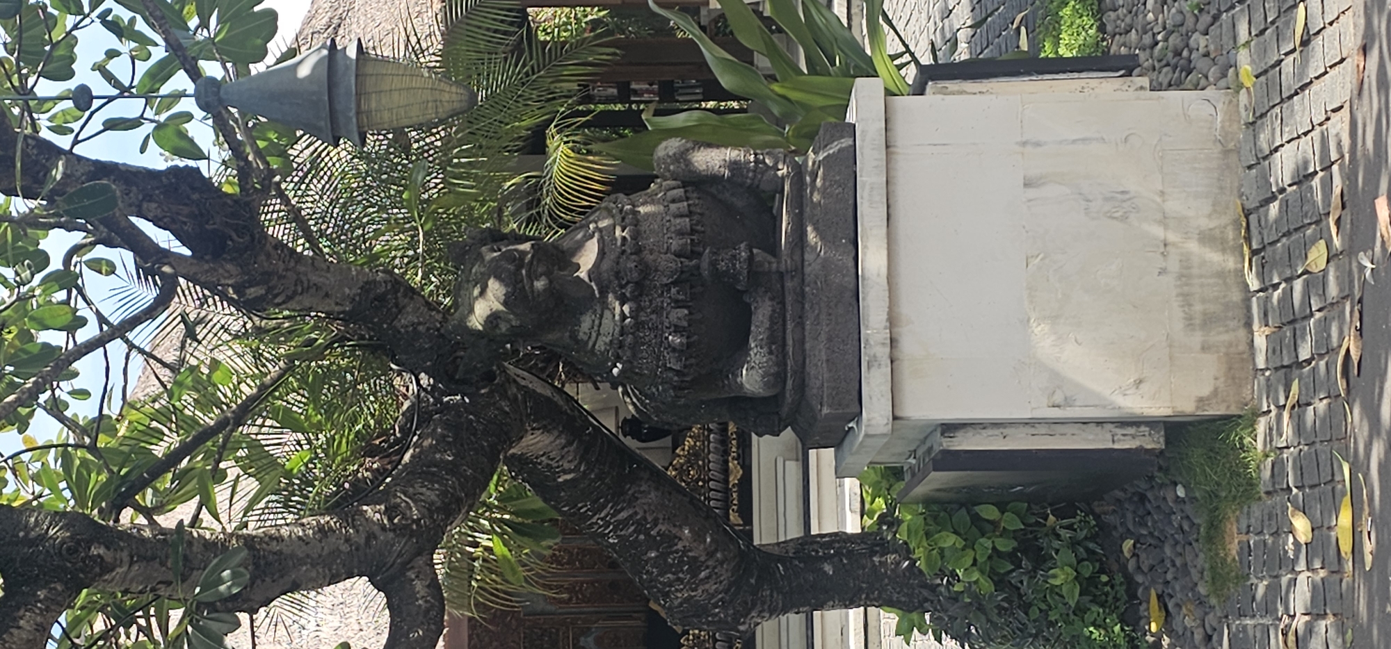 Tourist documents Balinese temple complex and tropical surroundings in Denpasar