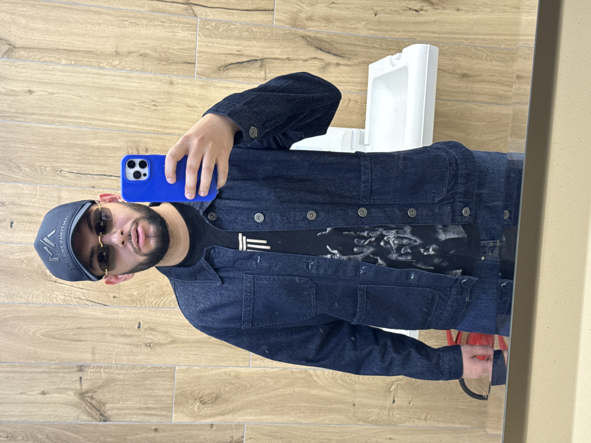 Person takes restroom selfie, drinks blue beverage in brief encounter