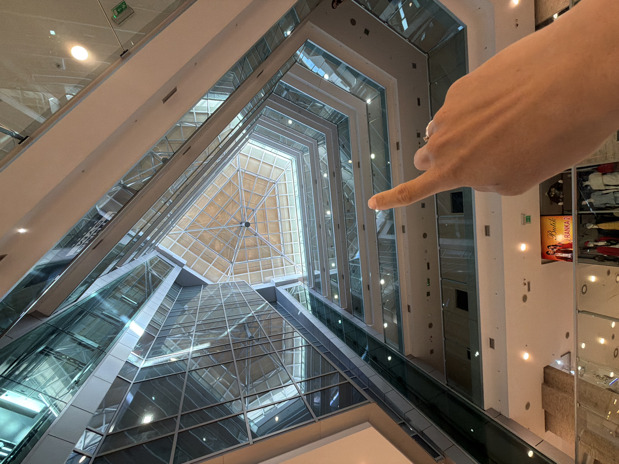 Woman takes selfies in glass atrium building in Budva