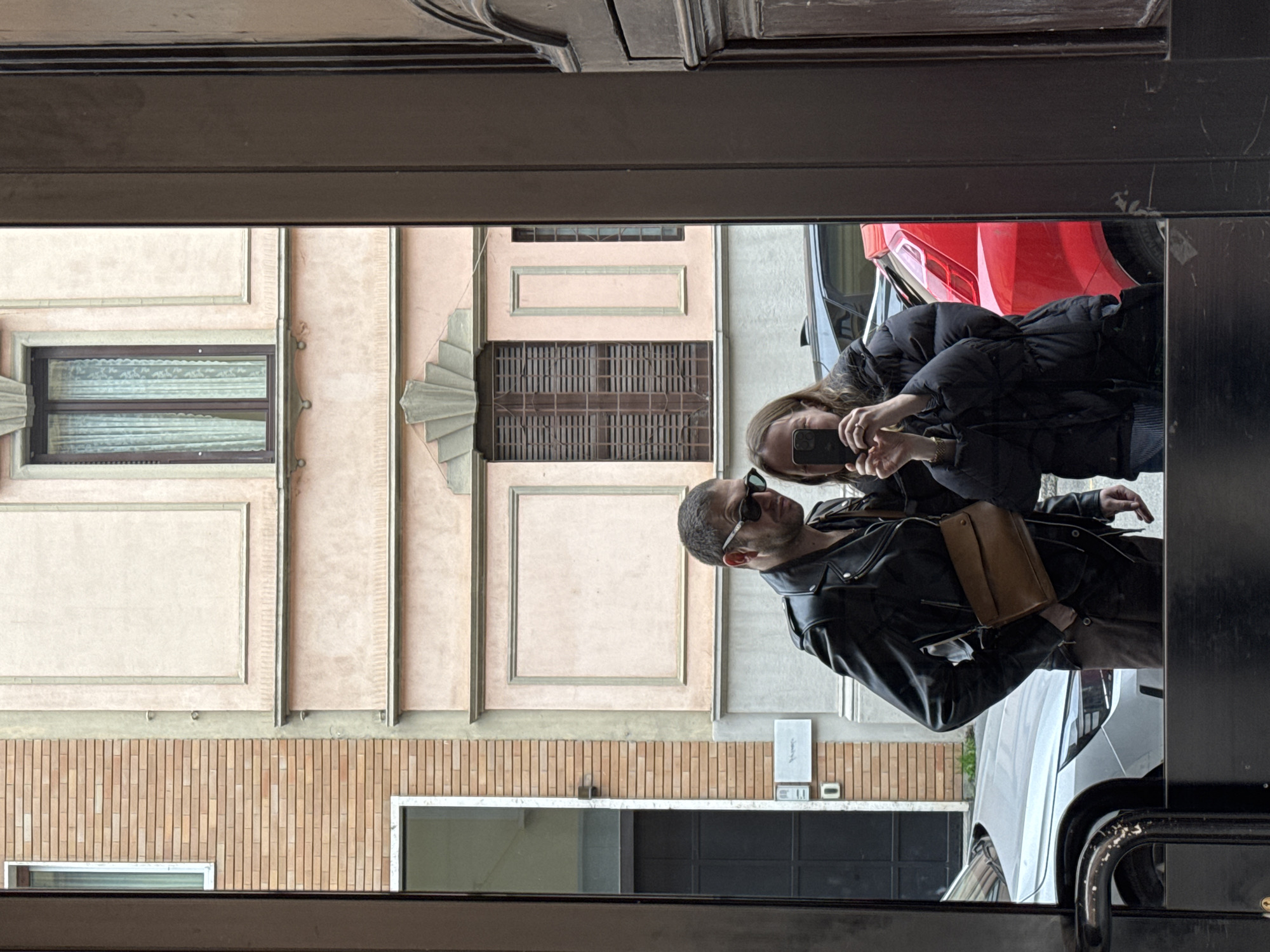 Two people reflected in Milan street glass surface