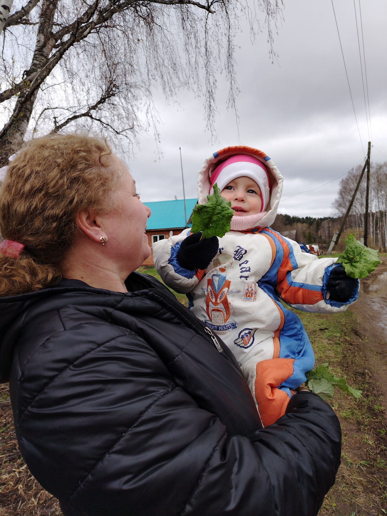 Woman, child enjoy outdoor moments with cat in Russian village