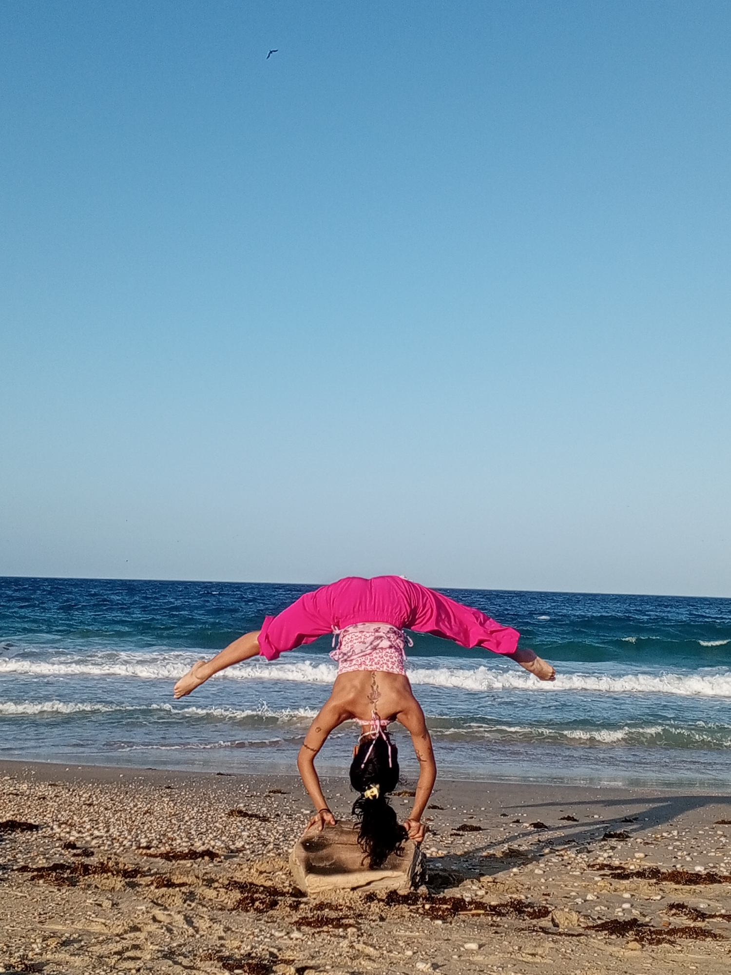 Woman performs beach yoga handstands in Porlamar, Venezuela