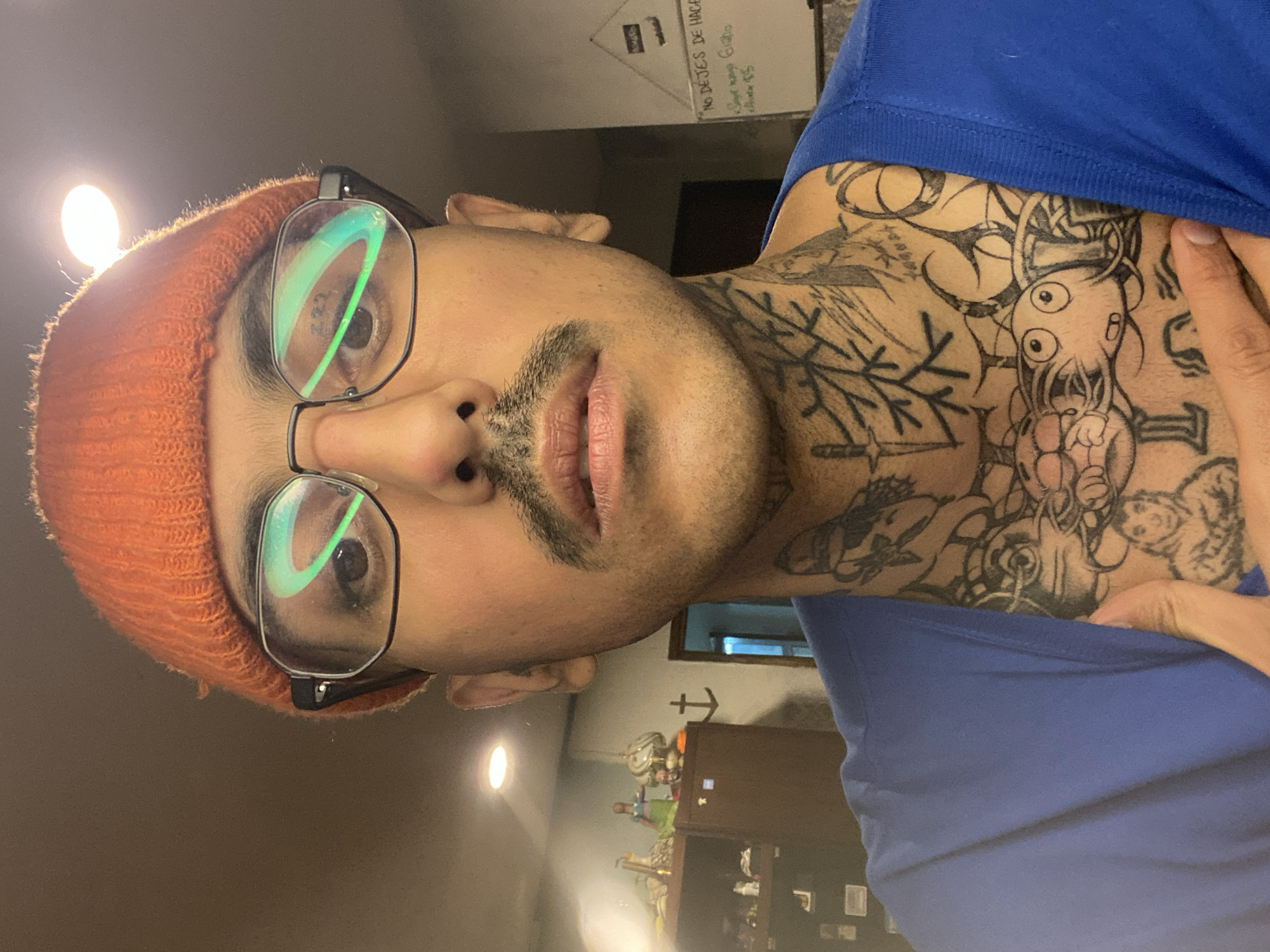 Tattooed man takes selfie in Ushuaia room