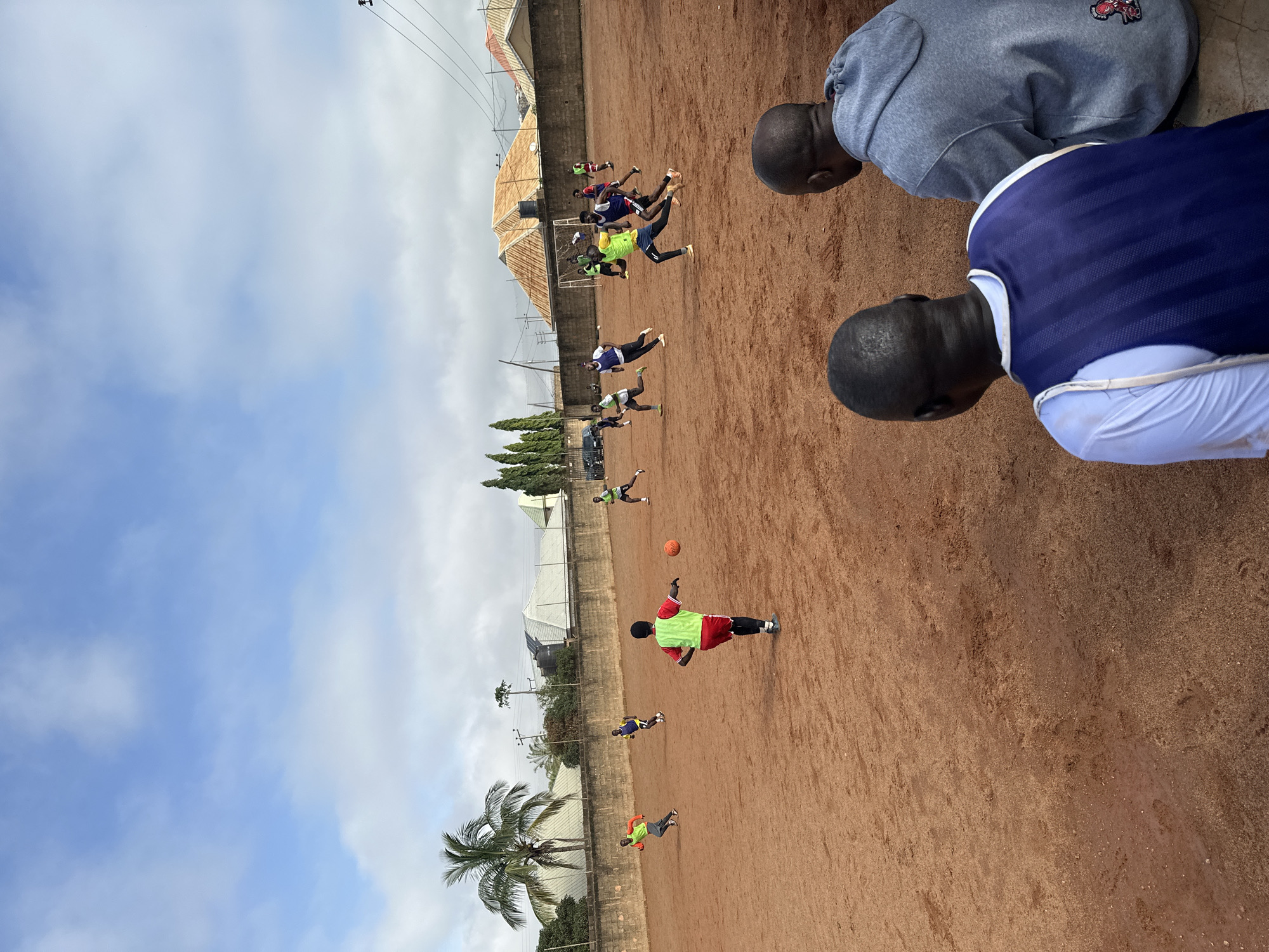 Pickup soccer on a red-dirt field in Jos, Nigeria
