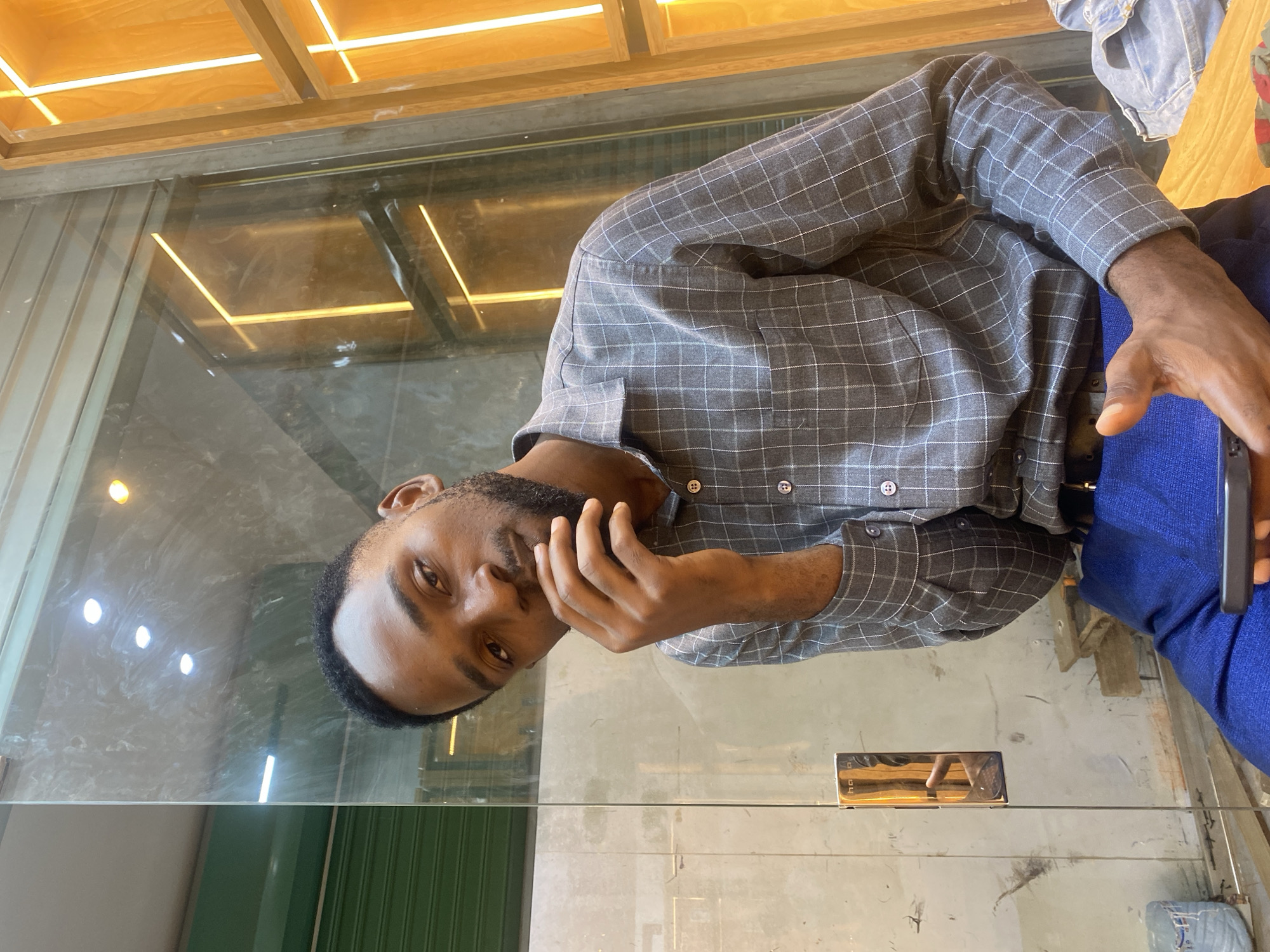 Man uses smartphone at indoor venue in Dar es-Salaam