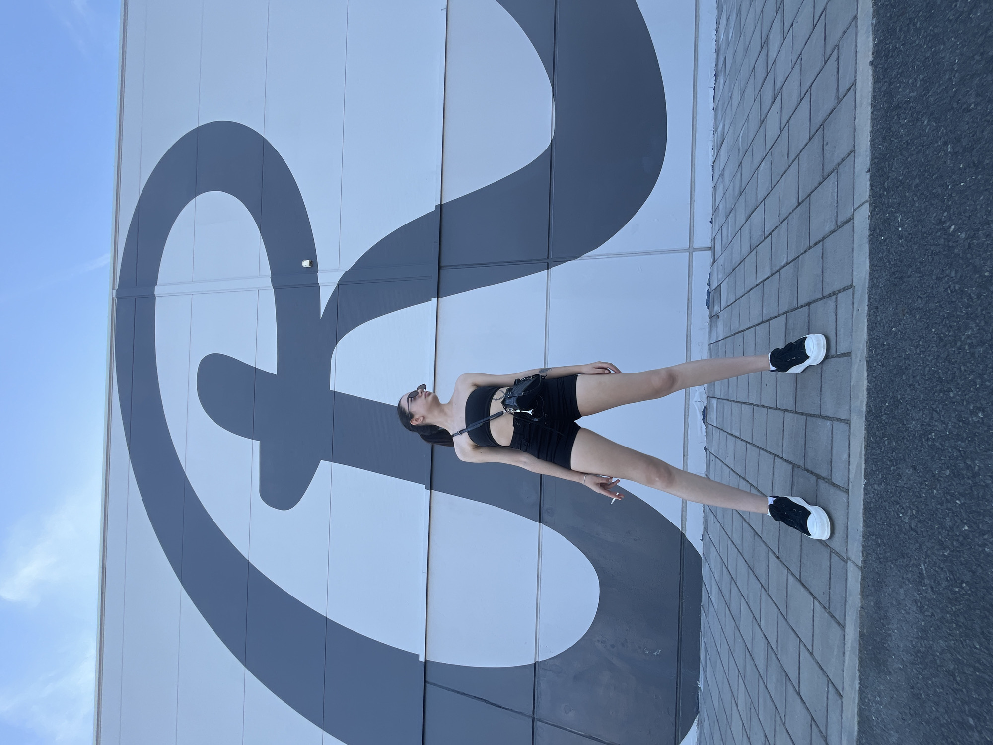 Posing against Pilsen's bold 'R' mural in all-black
