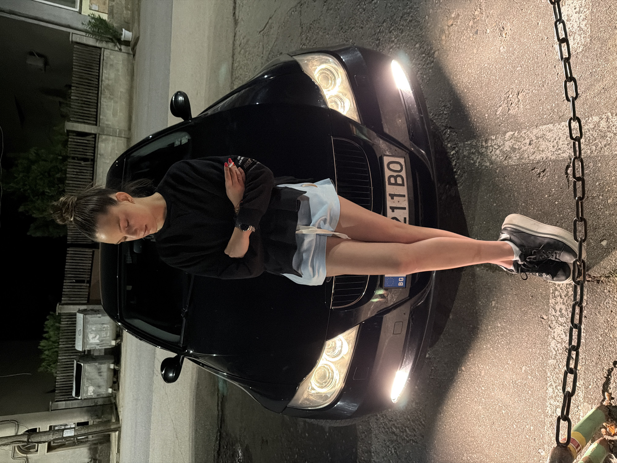 Woman poses on BMW hood in Kaleytsa, Bulgaria