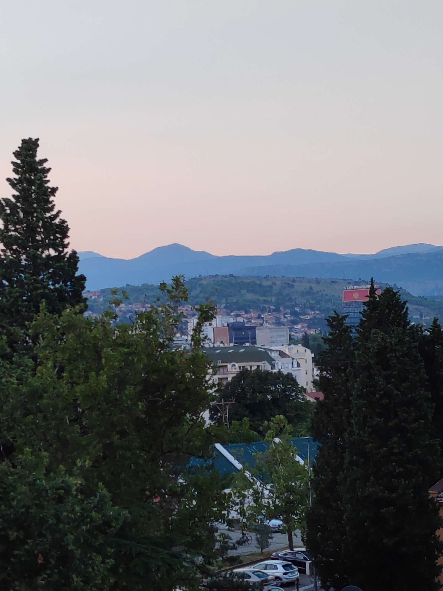 Podgorica at dusk, city and mountains under a pastel sky