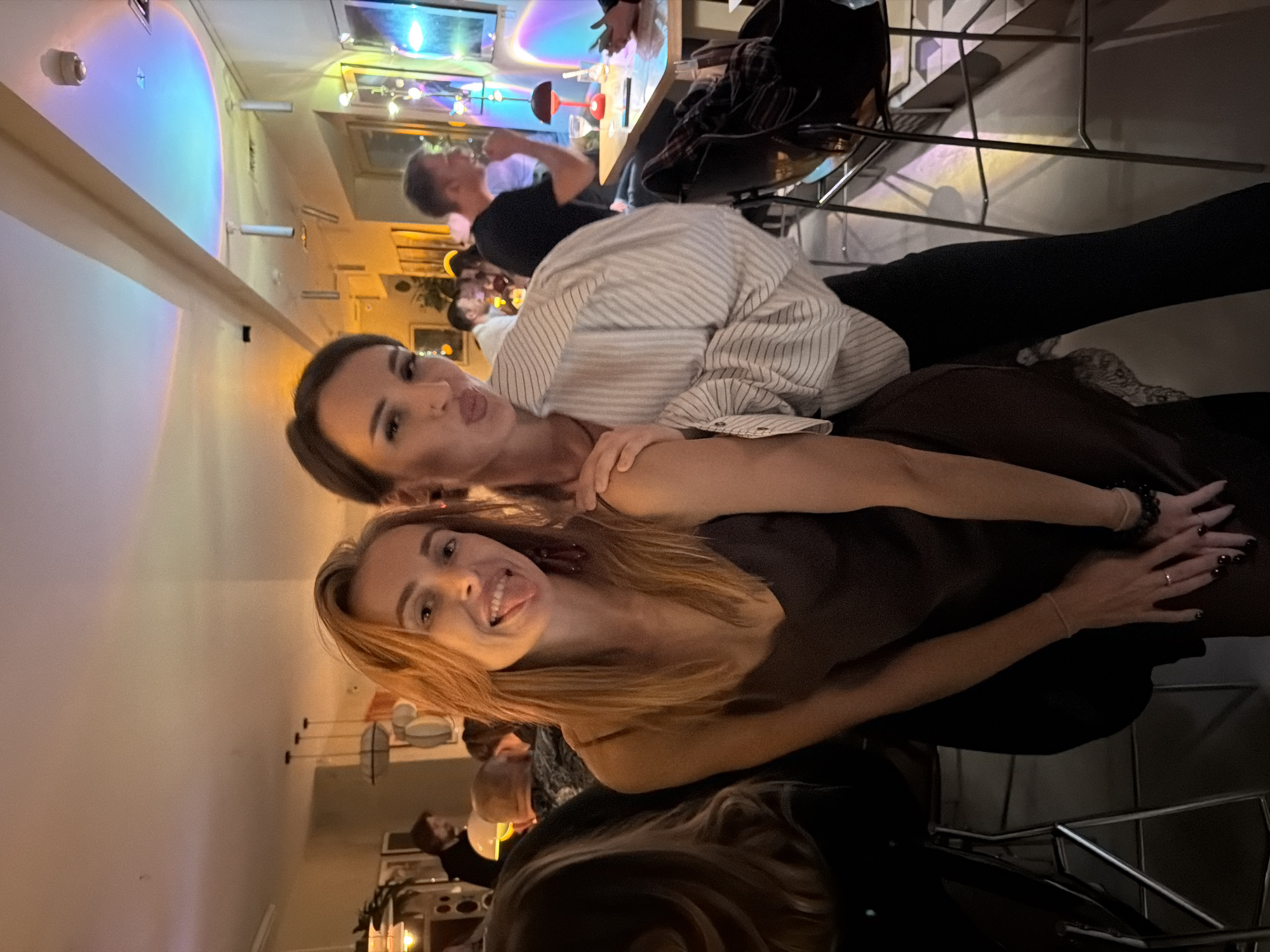 Two women enjoy drinks and photos at Krasnoyarsk restaurant