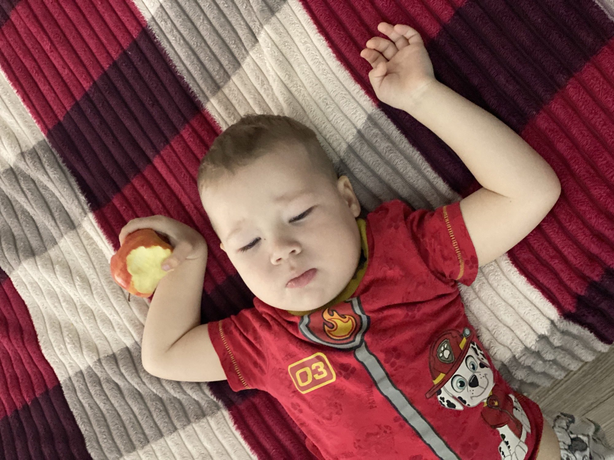Child sleeps on checkered blanket in Sochi
