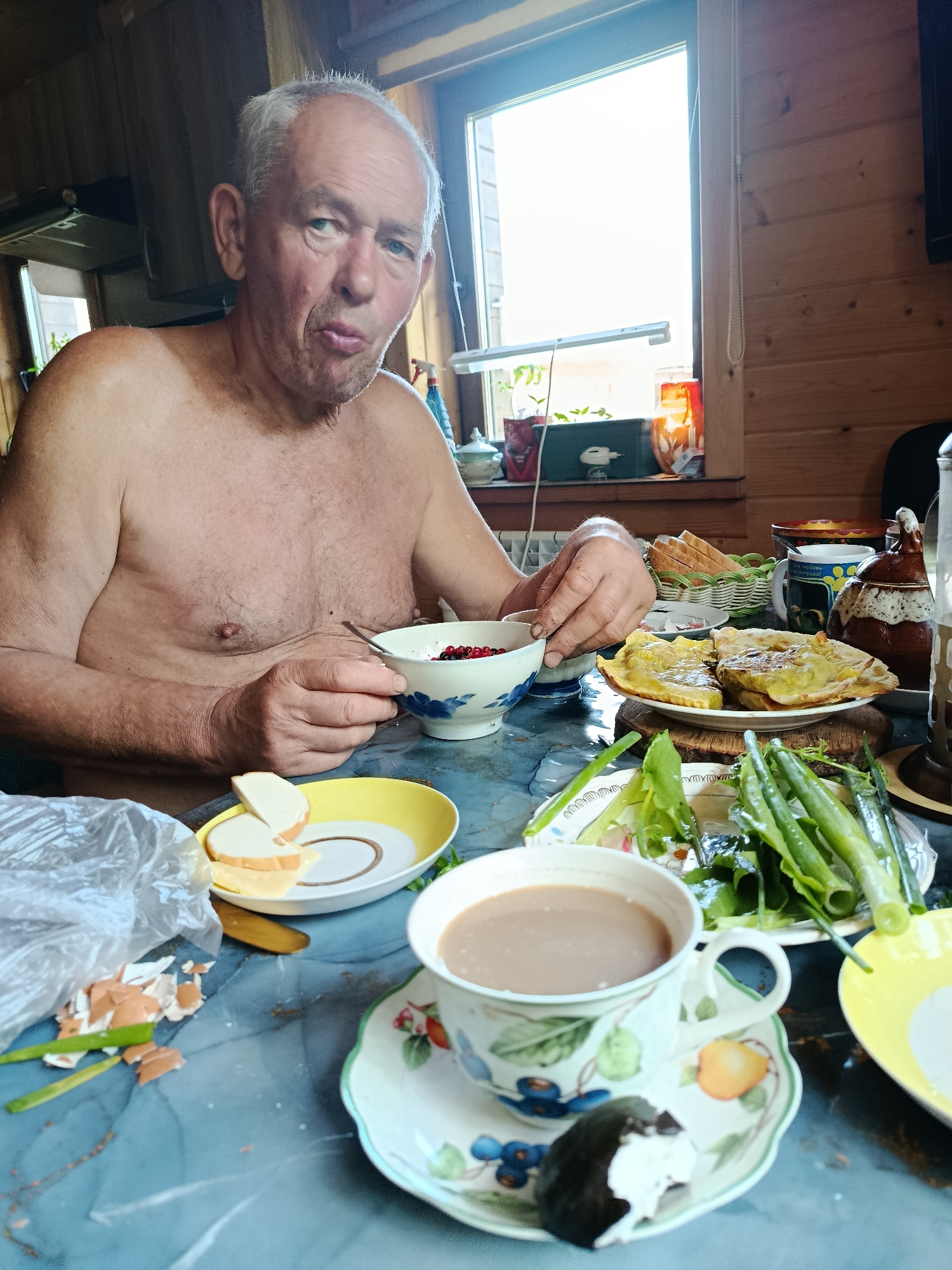 Elderly man enjoys traditional meal with berries and flatbreads