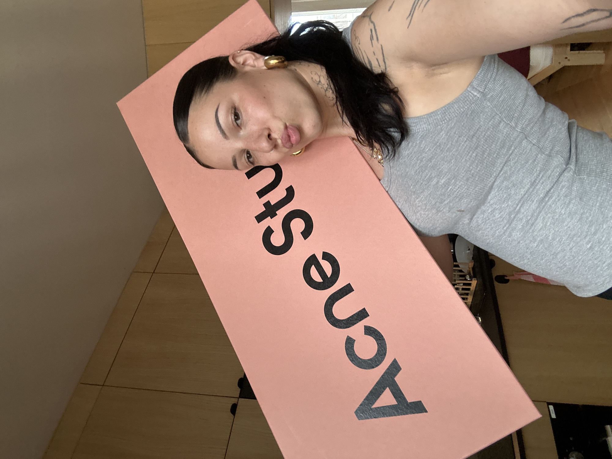 Woman poses with Acne Studios box in Saint-Ouen