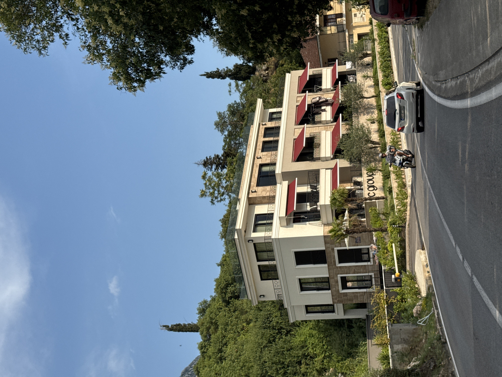 White hillside building with red awnings in Dobrota, Montenegro
