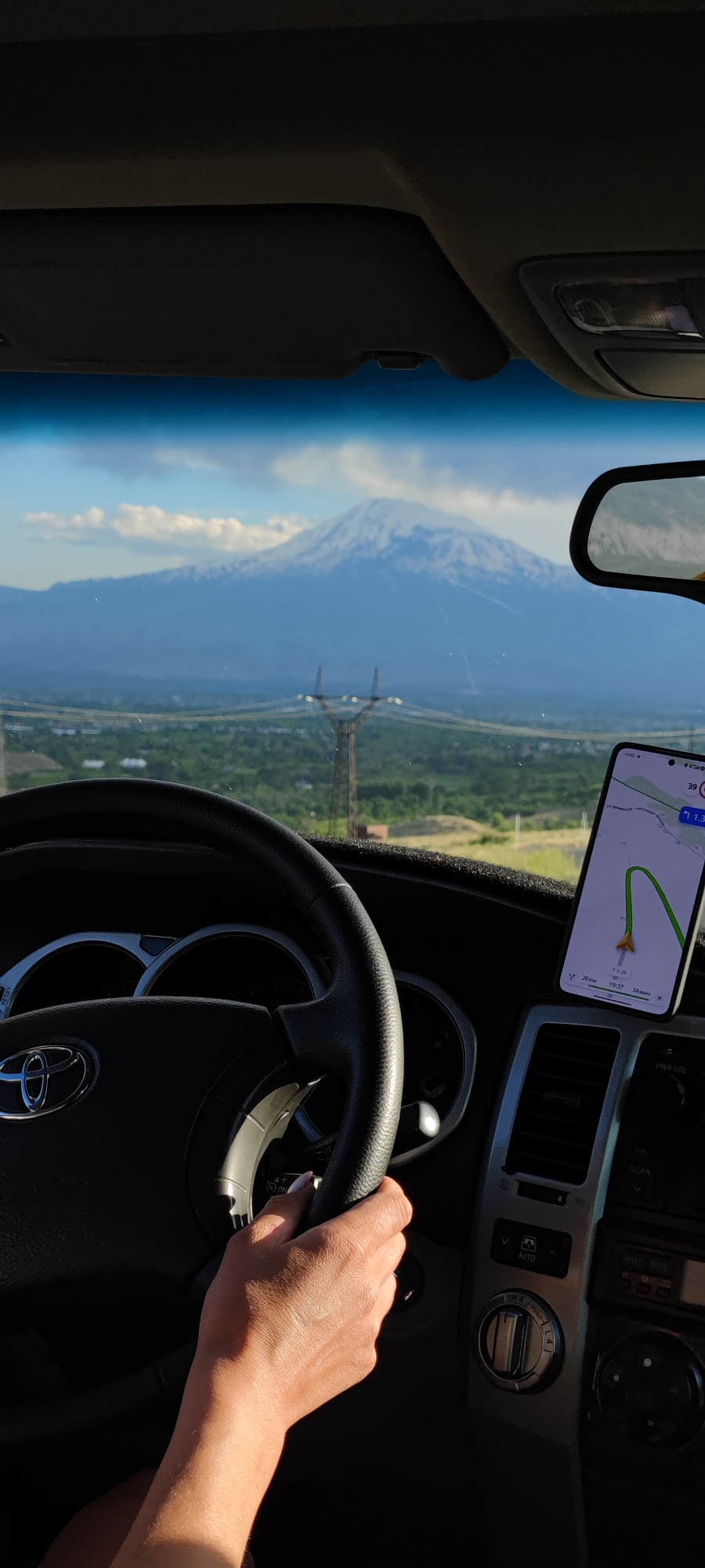 Snow-capped mountain view through a car windshield in Armenia