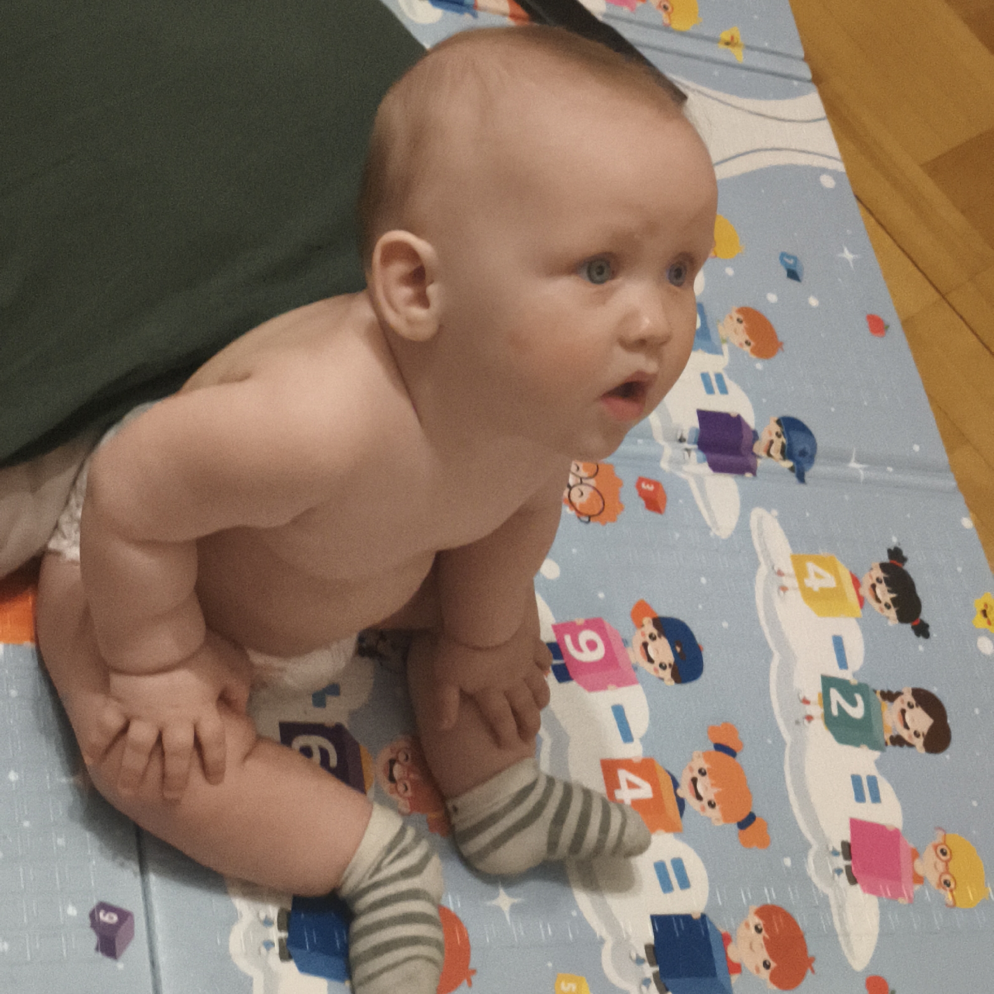 Baby and dog share playtime on colorful mat