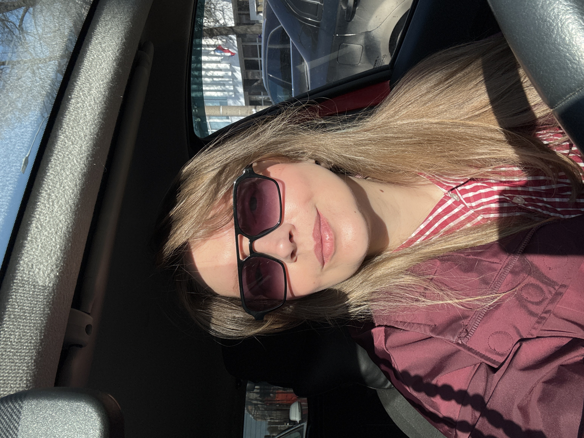 Woman photographed in car during sunny day in Izhevsk