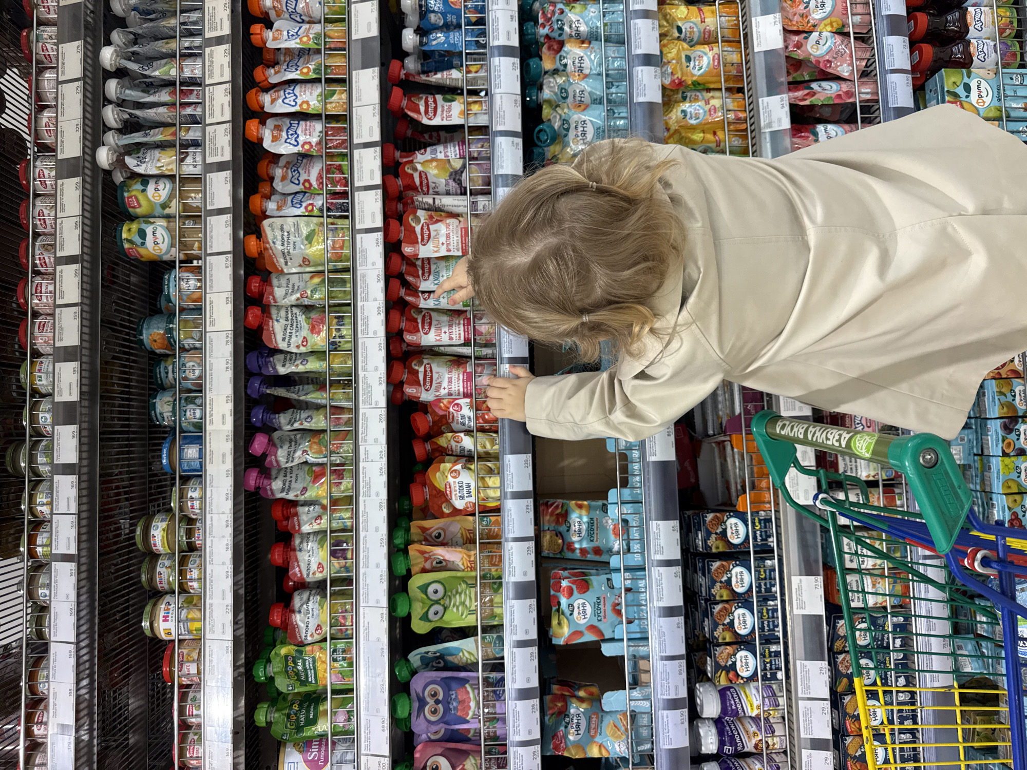 Child shops with toy cart in Moscow supermarket