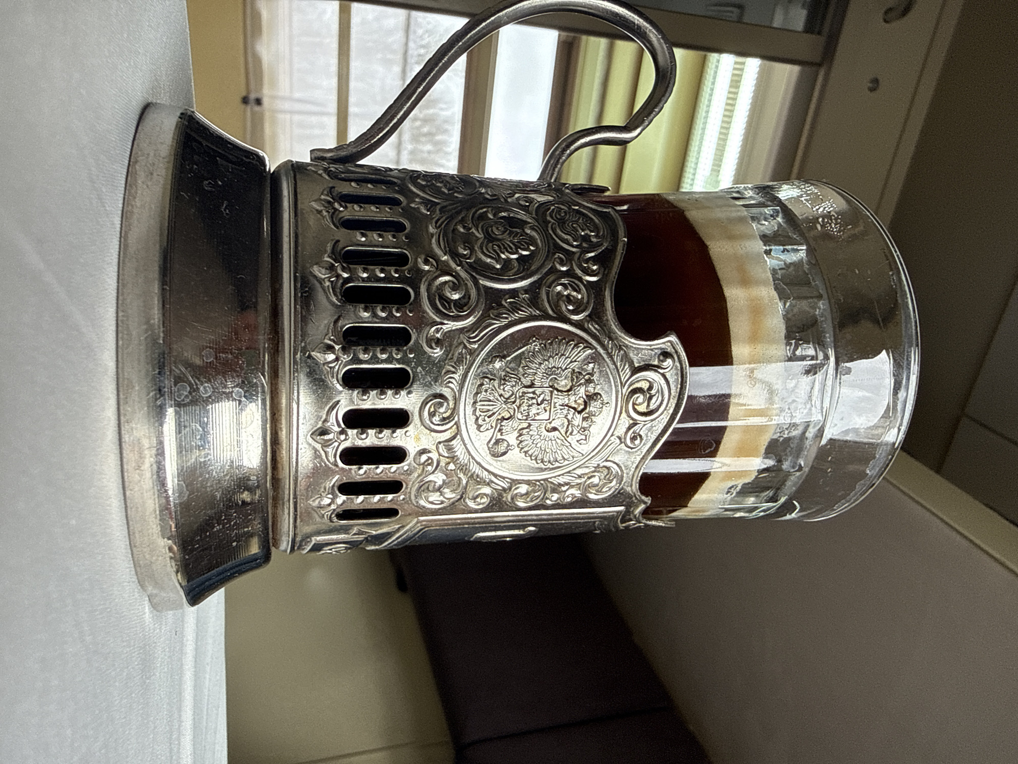 Traditional Russian podstakannik holds layered beverage in Vyglyadovka