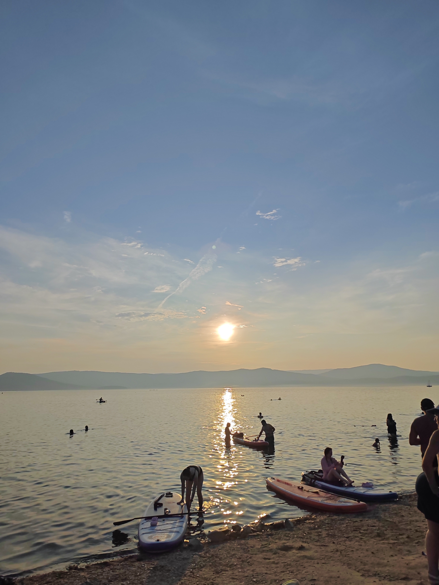 Summer afternoon at Lake Turgoyak, beach crowds and golden sunset