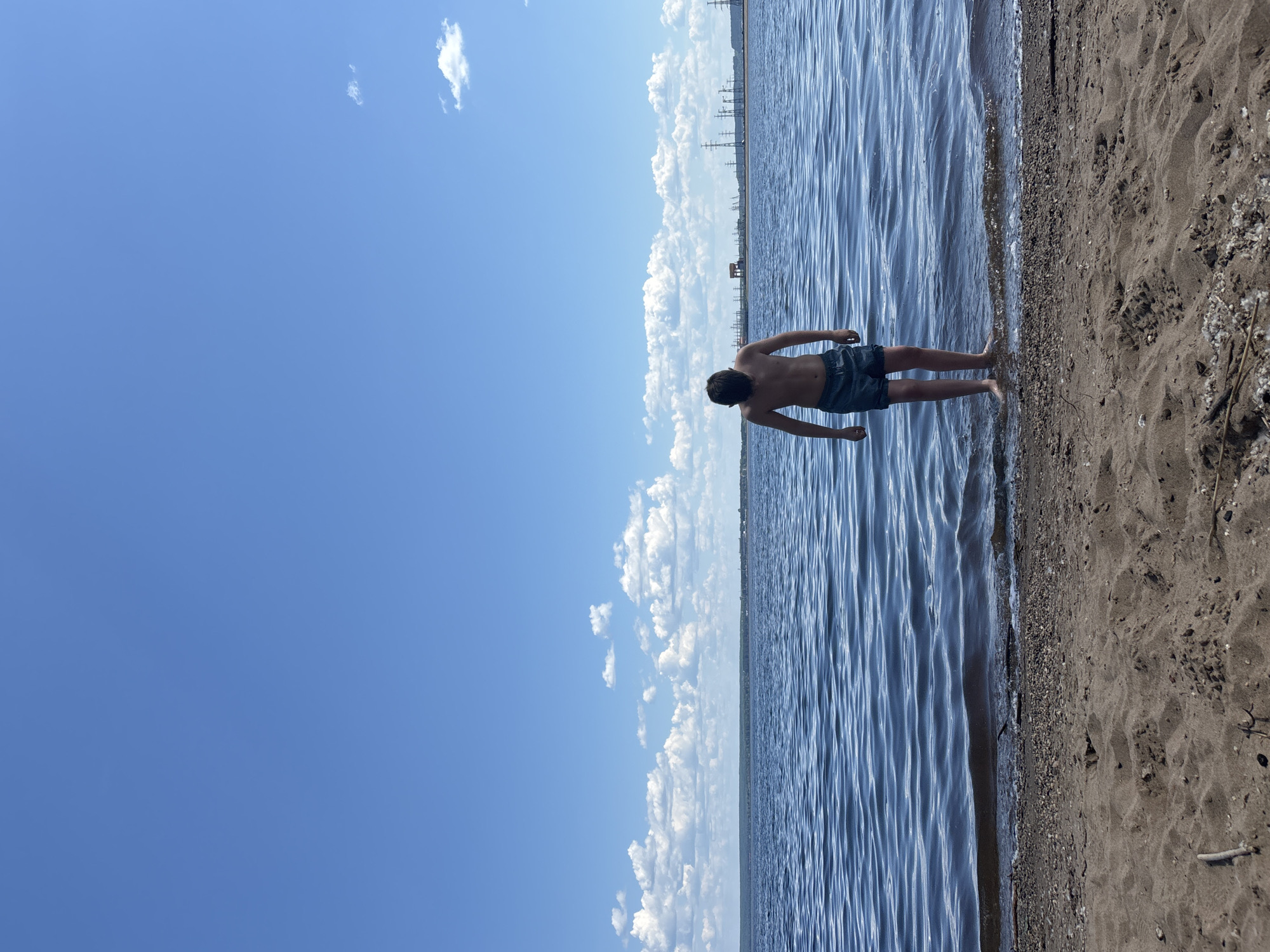 Young man contemplates calm water in Chaikovsky, Russia