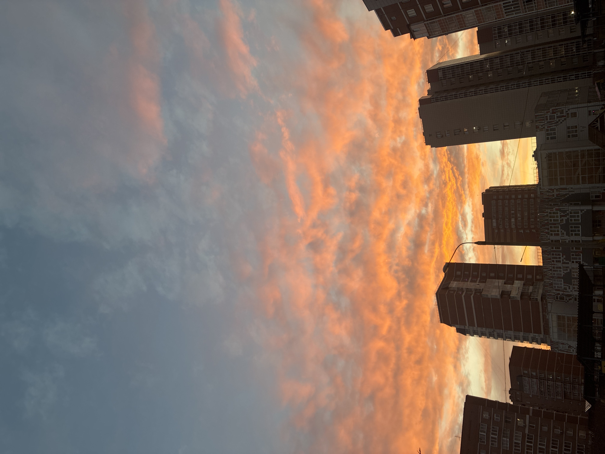 Vivid sunset colors illuminate urban sky during twilight hours